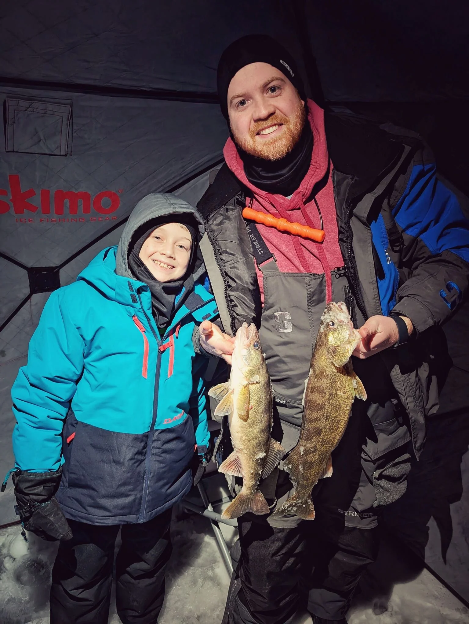  A young angler and guide posing with walleye inside a bright Eskimo ice shanty during a guided winter trip on Saginaw Bay with Reel Fish'n LLC.   