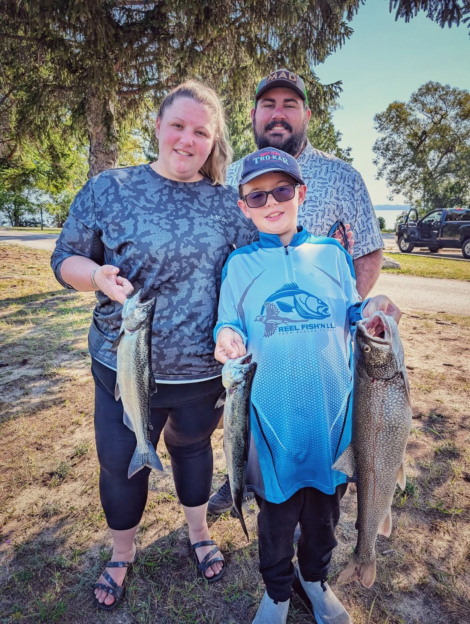 A happy family with their catch of Grand Traverse Bay salmon; our late-summer trips are perfect for making memories with the kids.