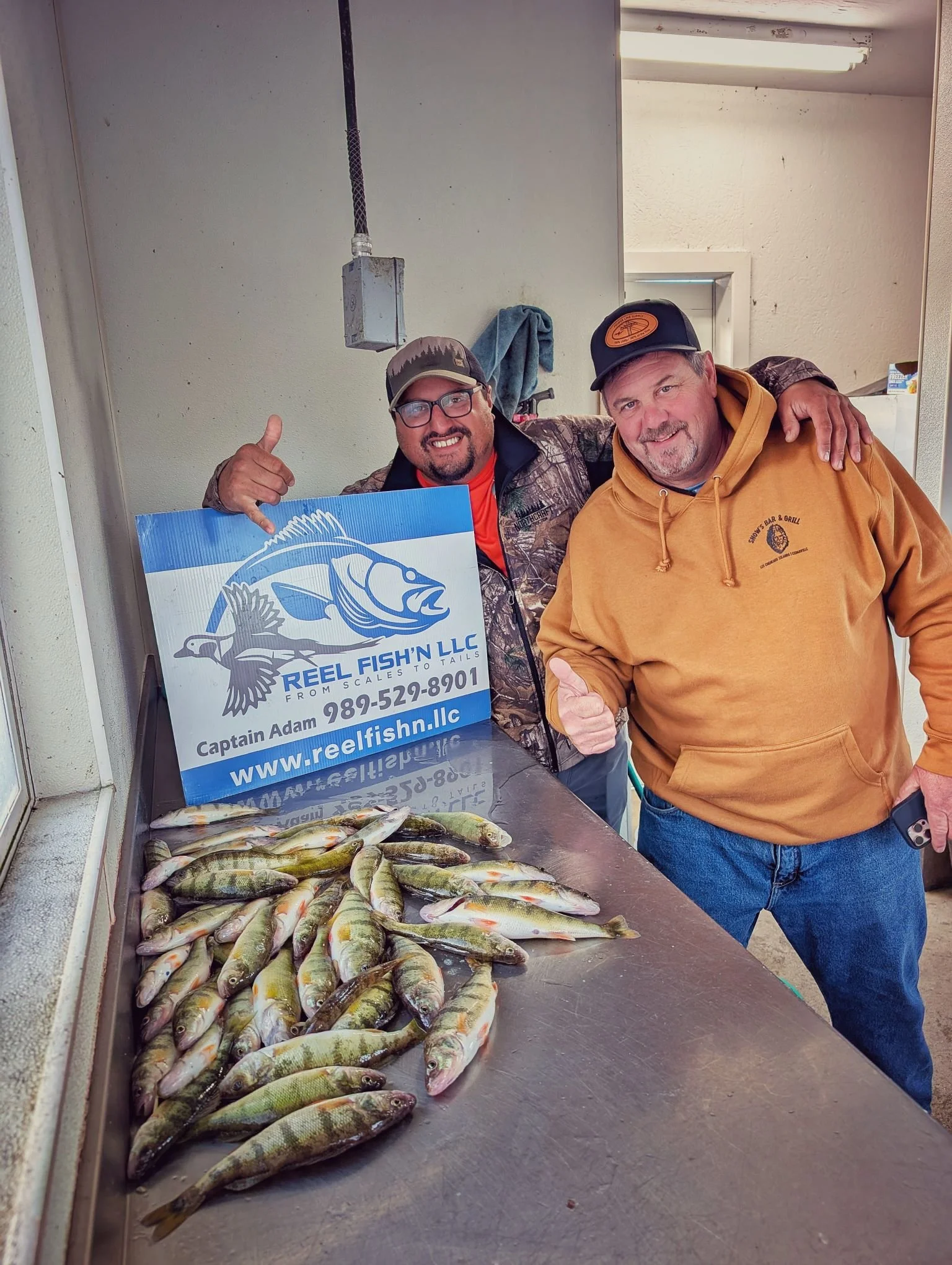 Two happy fishermen with a massive spread of Drummond Island yellow perch caught while launching from the Drummond Island Yacht Haven.