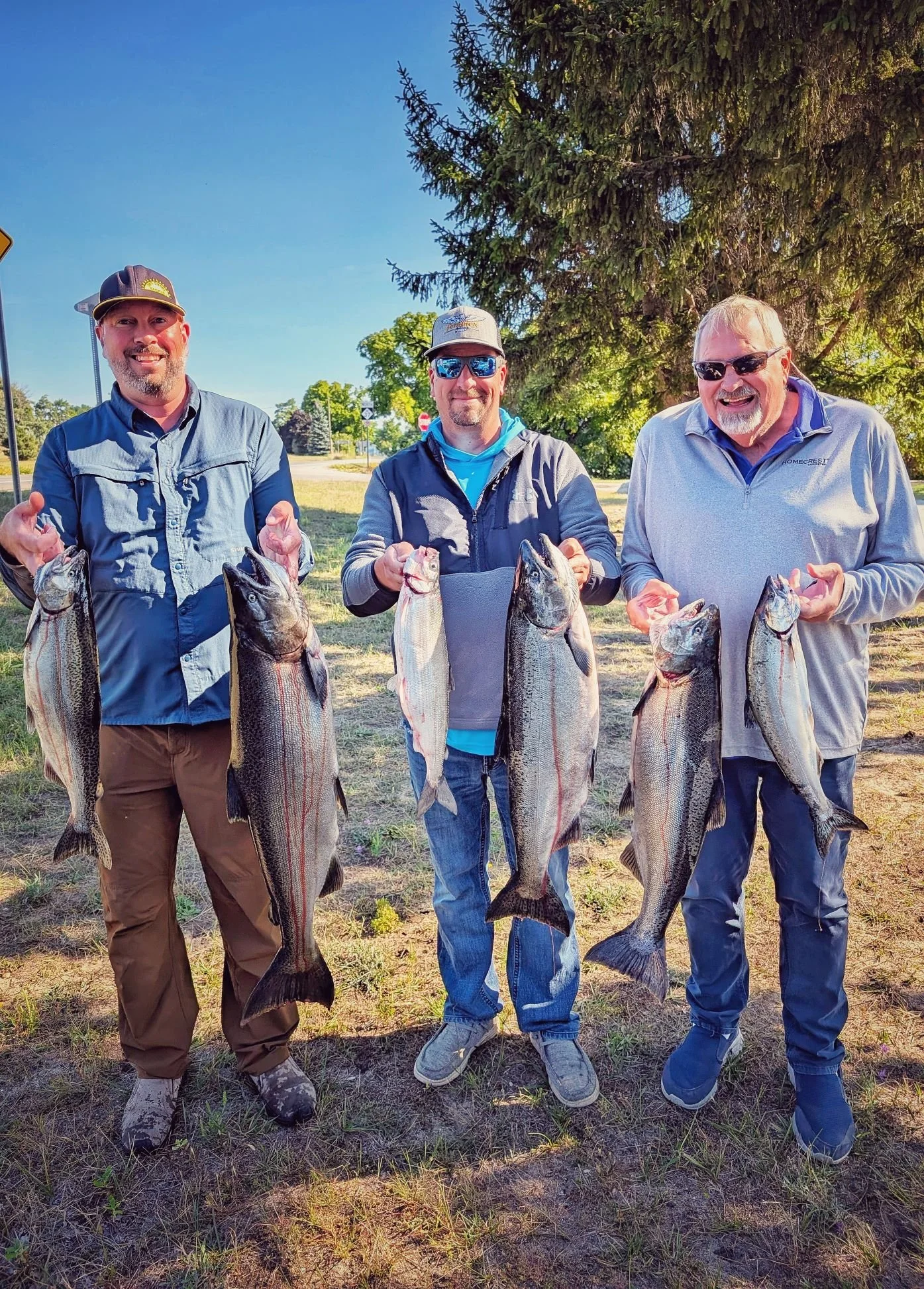 A group of anglers displaying a heavy limit of late-summer King Salmon and Lake Trout caught while trolling Grand Traverse Bay with Reel Fish'n.