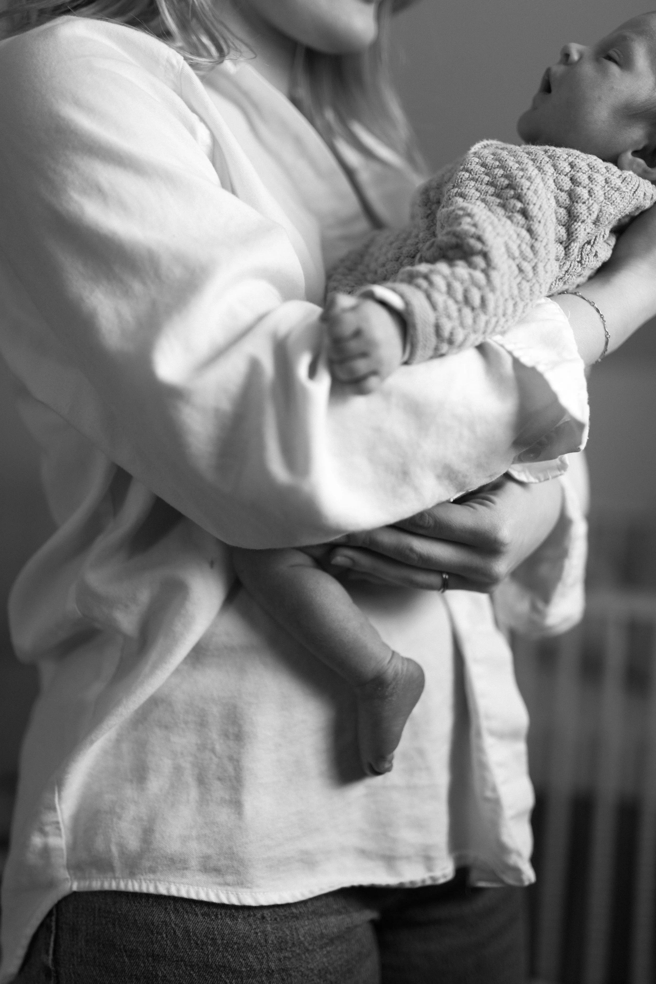 A woman holding a sleeping baby in her arms.