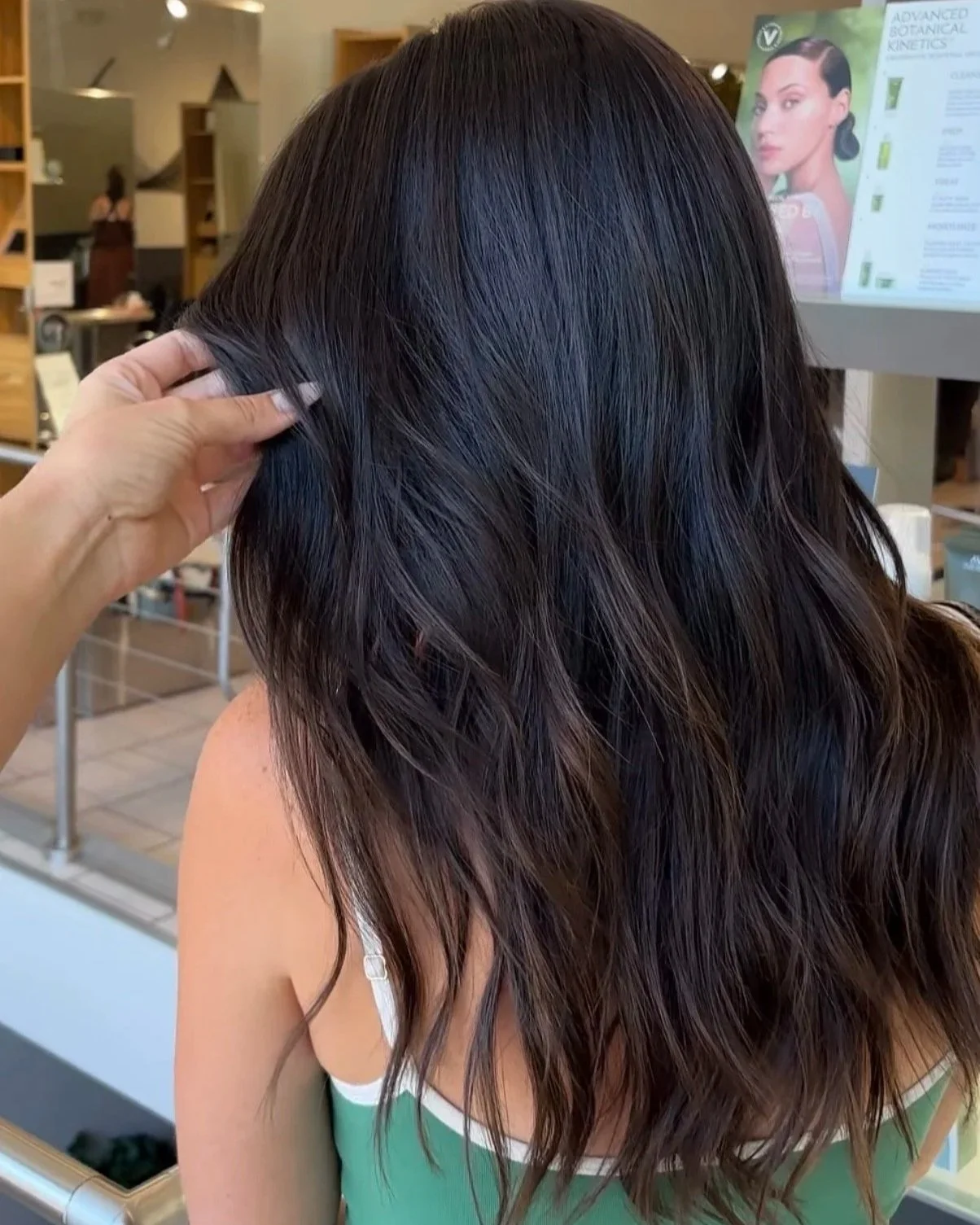 Dark brown wavy hair with soft, dimensional color by a Berenices colorist in Denver