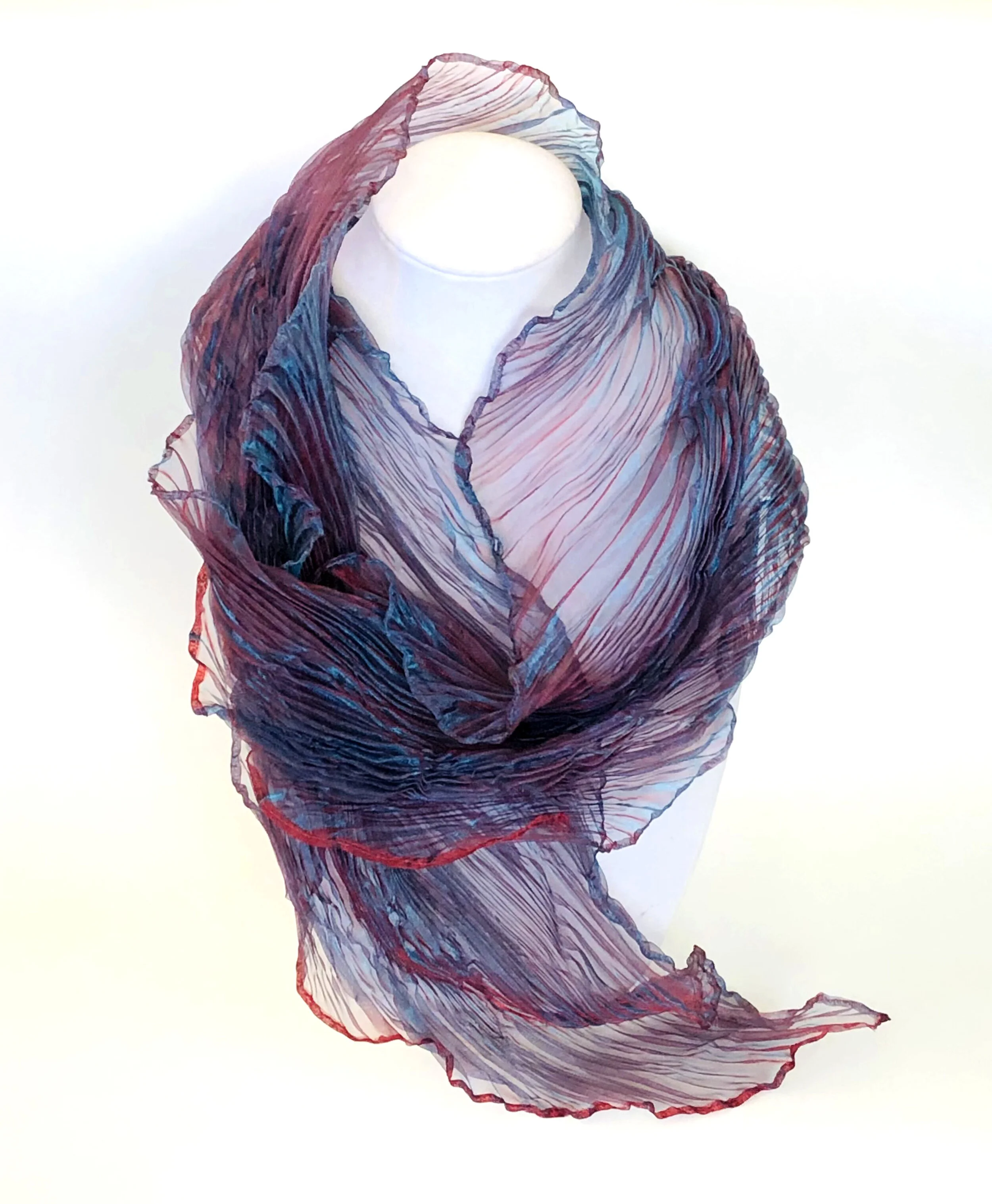 Hand Pleated Chiffon Scarf 10 "X 56" This beautiful hand pleated chiffon scarf was made using a pole 
wrapping technique. The burgundy and blue colours in the warp & weft yarns produces a very striking 
luminescent effect.
Retail: $130
Opening Bid; $