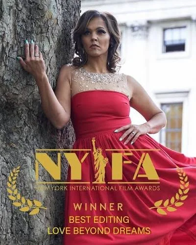 A woman in a red dress standing next to a tree, posing with one hand on the tree and the other on her hip, with the NYIFA (New York International Film Awards) logo and text overlay about winning Best Editing for 'Love Beyond Dreams'.