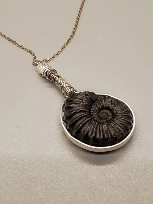 Silver pendant with black ammonite