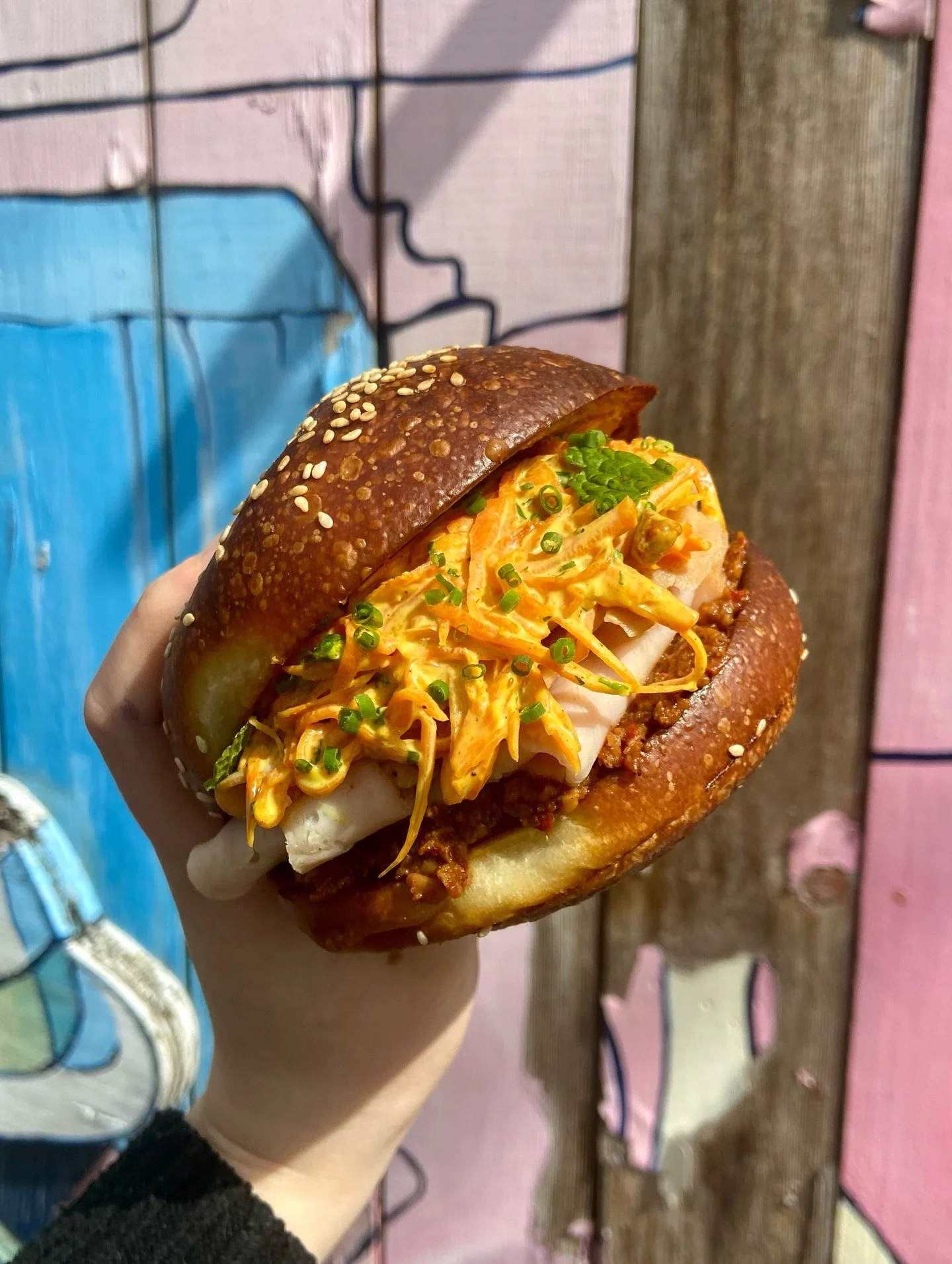 DELI CHICKEN SANDO W/ CURRIED CARROT SLAW 🥕 thinly sliced chicken, carrot slaw with a curry mayo and rum-soaked golden raisins and a walnut muhammara spread! Served on our house potato bun with mint, cilantro and a lime wedge 🍋&zwj;🟩 Available for