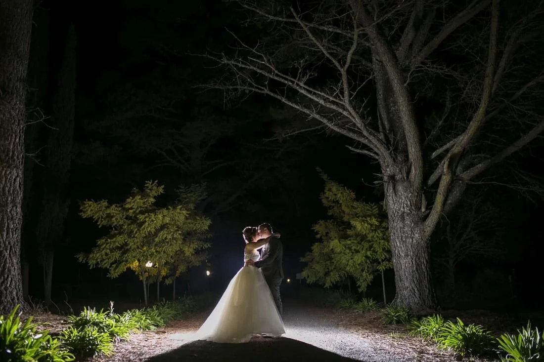 bride and grooms kissing at night
