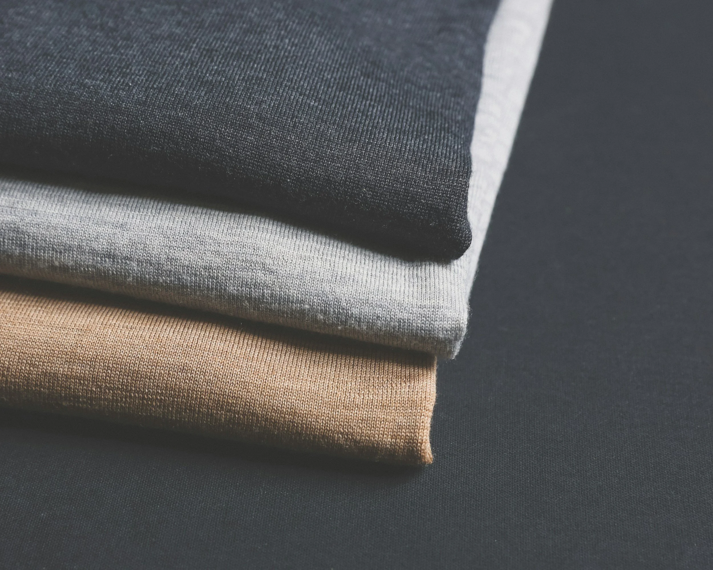 Pile of neutral core wardrobe knitwear in a capsule wardrobe