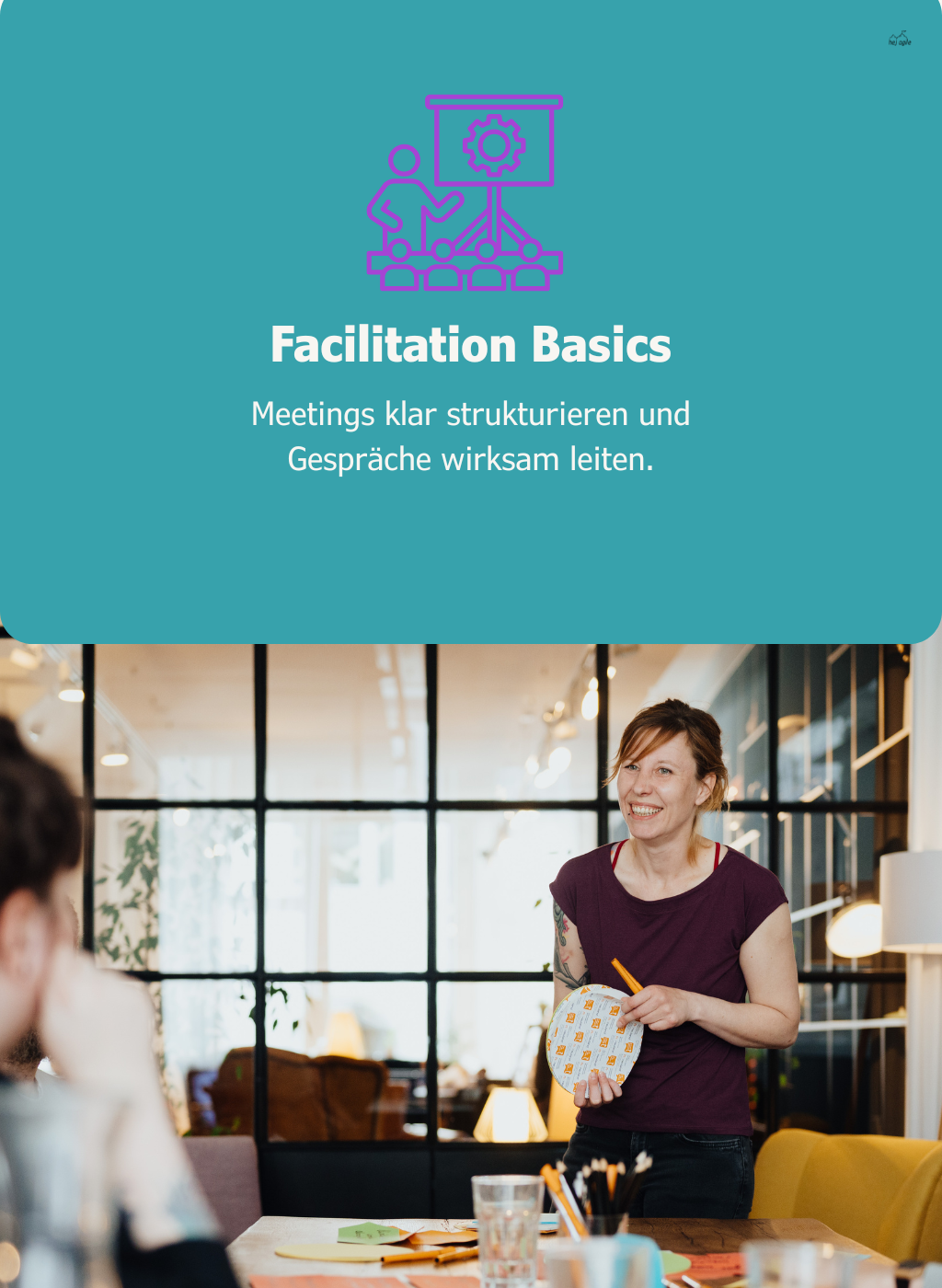 Grafik mit türkisem Hintergrund und der Überschrift „Facilitation Basics“, darunter ein Foto aus einem Workshopraum, in dem eine stehende Person Moderationsmaterial hält und mit Teilnehmenden am Tisch arbeitet.