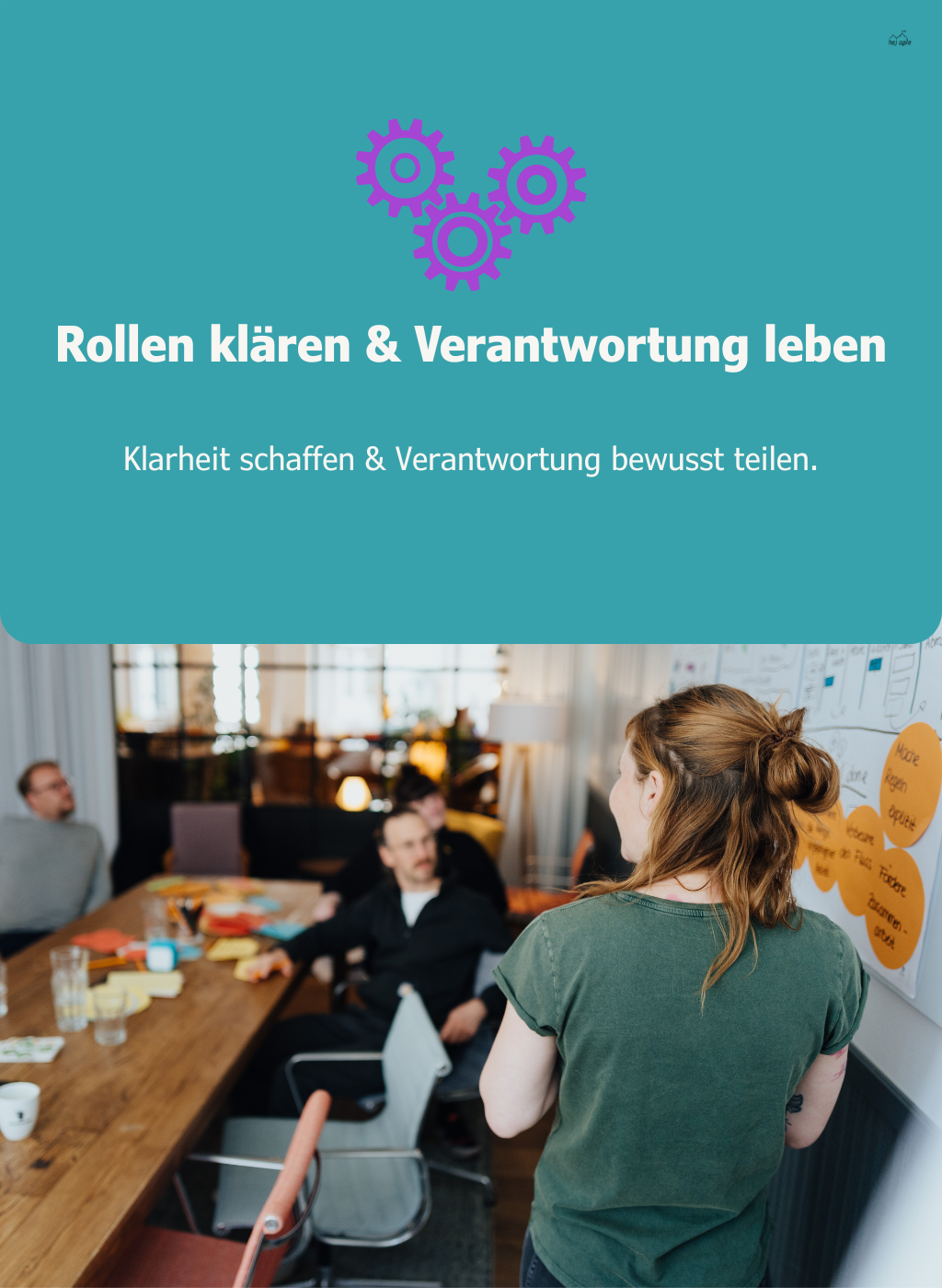 Workshop-Situation mit einer Person vor einem Board, die mit dem Team über Rollen und Aufgaben spricht – Symbol für Klarheit und gemeinsame Verantwortung.