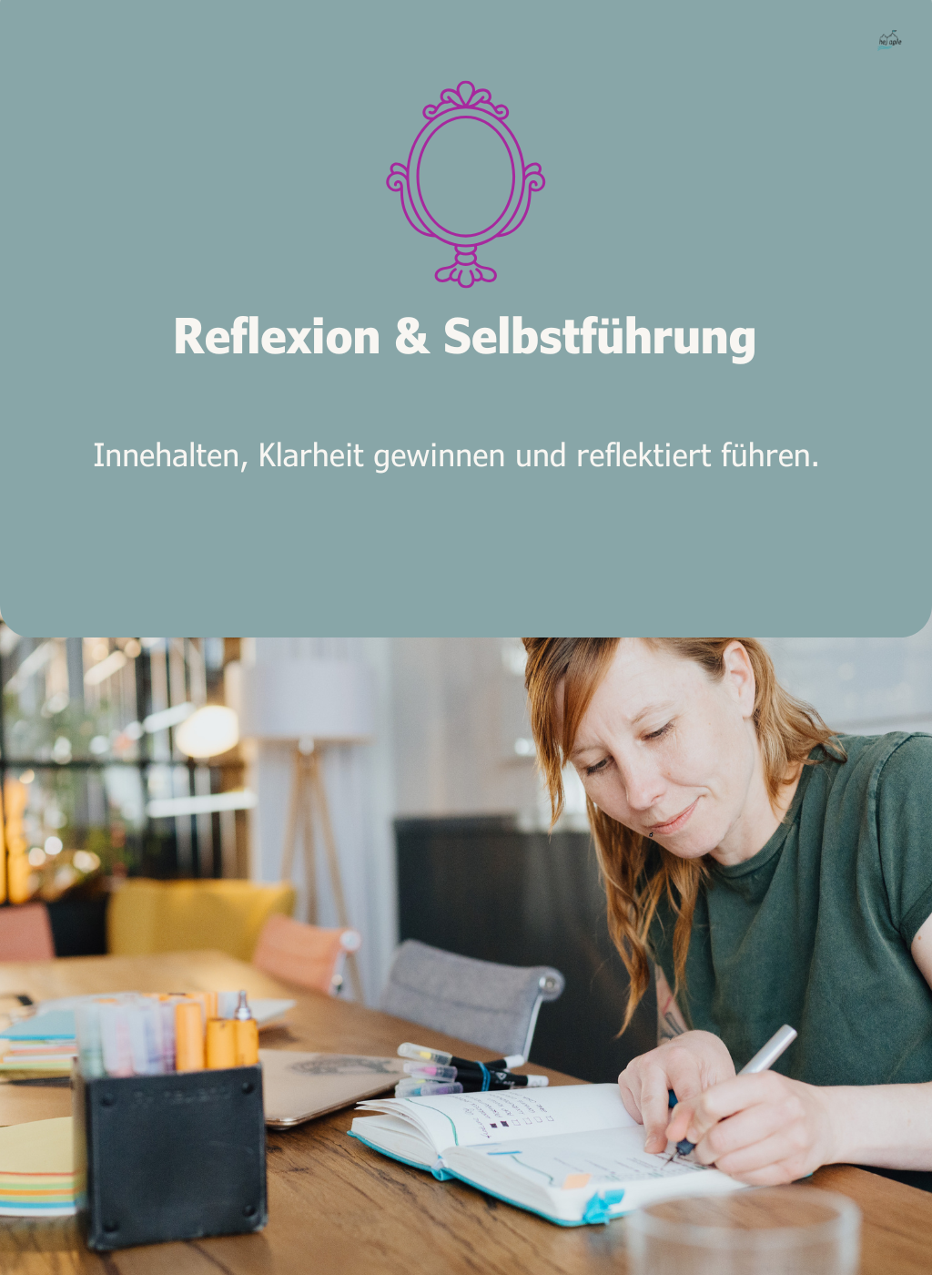Person sitzt am Tisch und schreibt konzentriert in ein offenes Notizbuch – Symbol für Innehalten und bewusste Selbstführung.