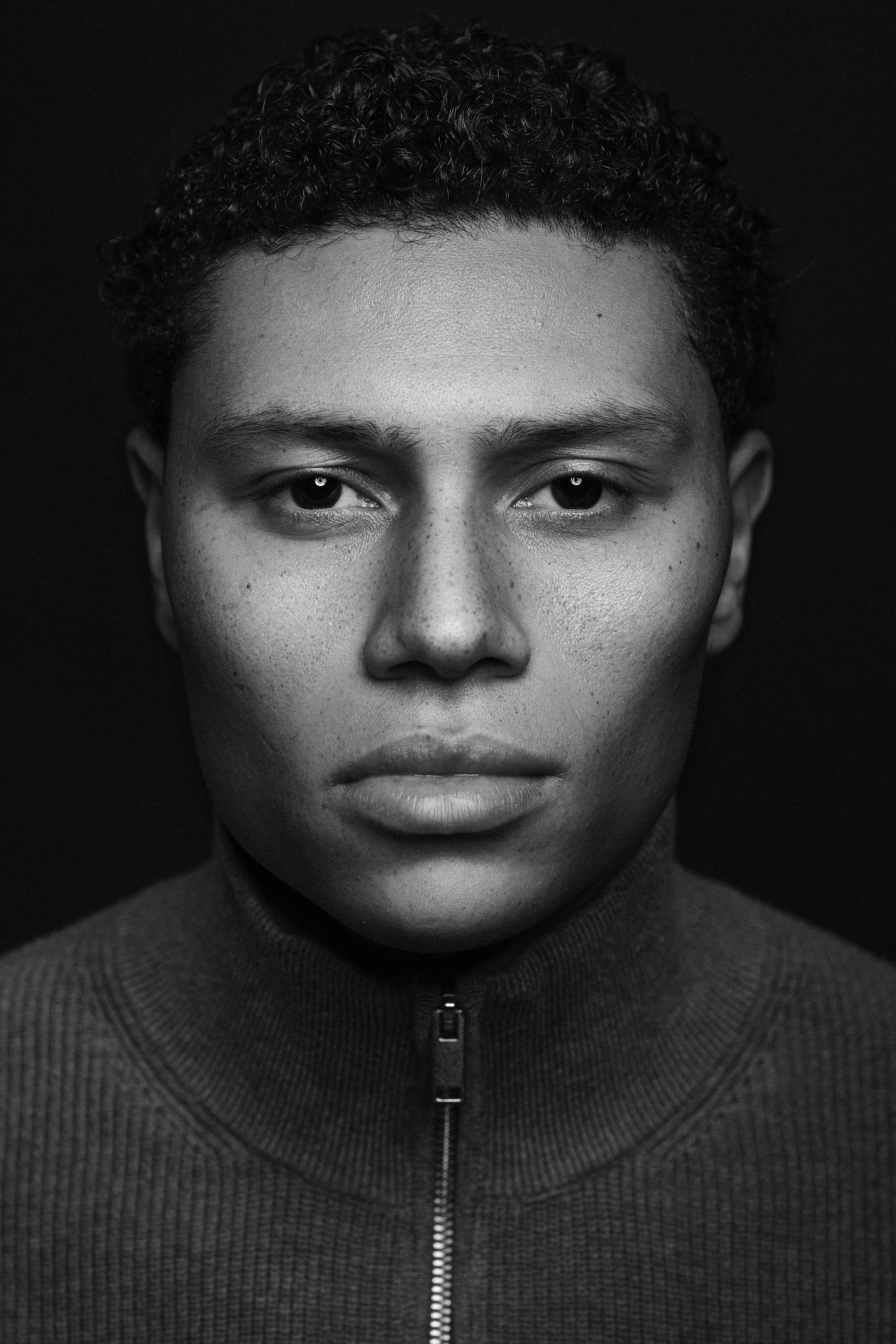 Zwart-wit frontaal portret jong mannelijk model met sterk contrast — Studio Wartenbergh Den Bosch