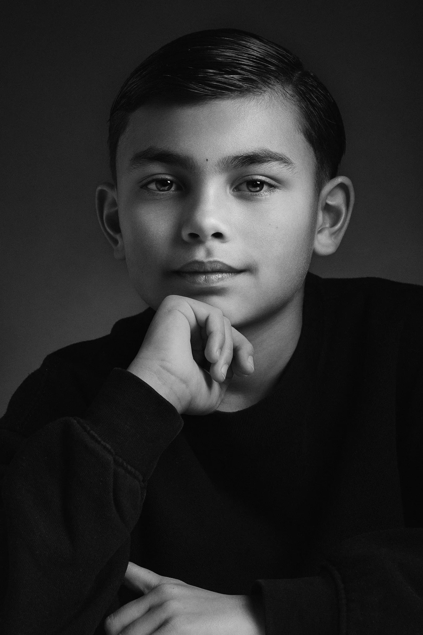 Zwart-wit portret jongen met nadenkende blik, studiobelichting — Studio Wartenbergh Den Bosch