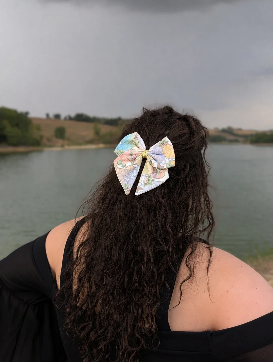 Nœud cheveux Sansu tissu coréen paysage pastel, porté en semi-attache sur cheveux bruns bouclés, vue de dos.