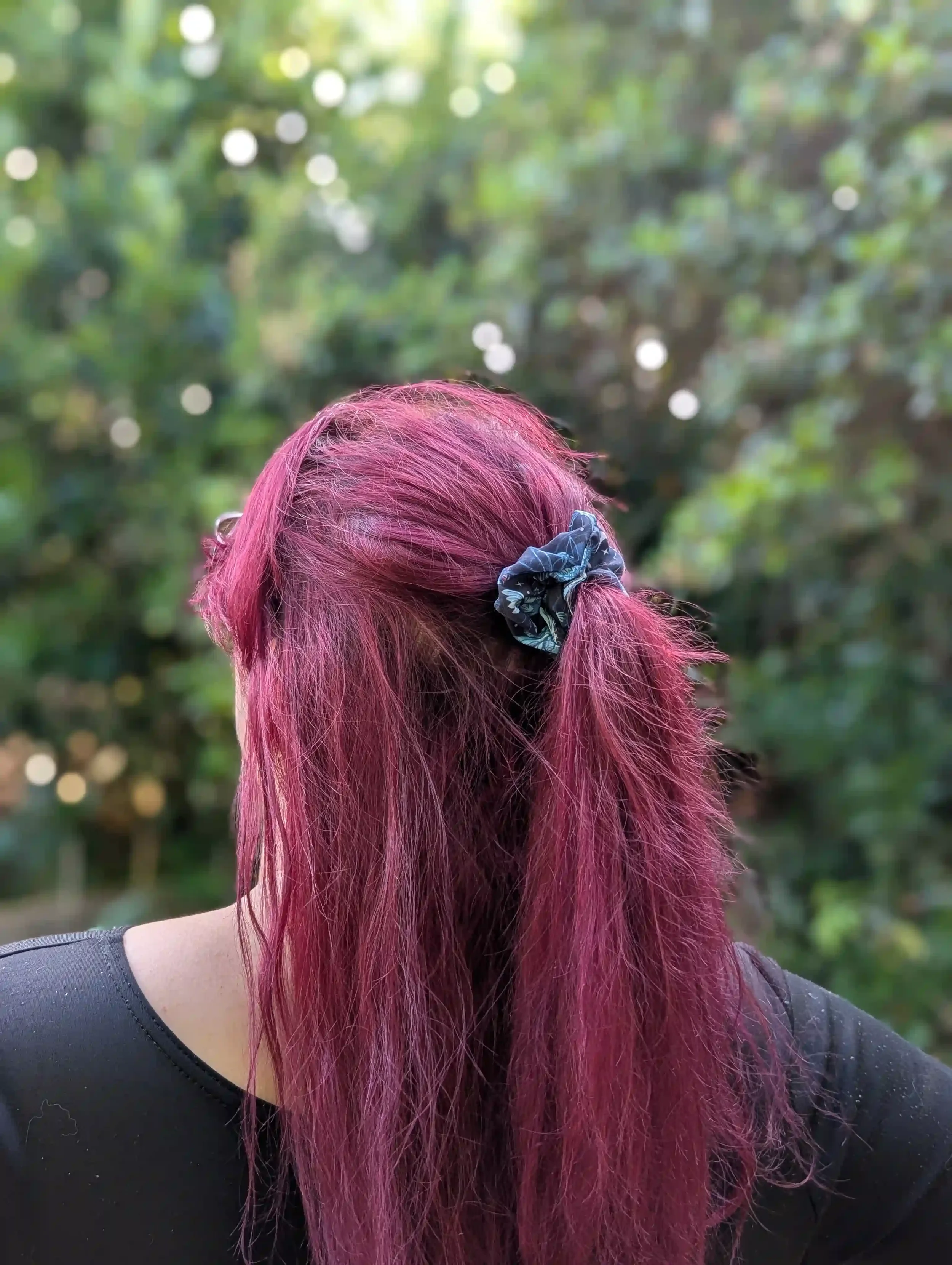 Petit chouchou Cristal noir et bleu porté sur une demi-queue de cheveux.