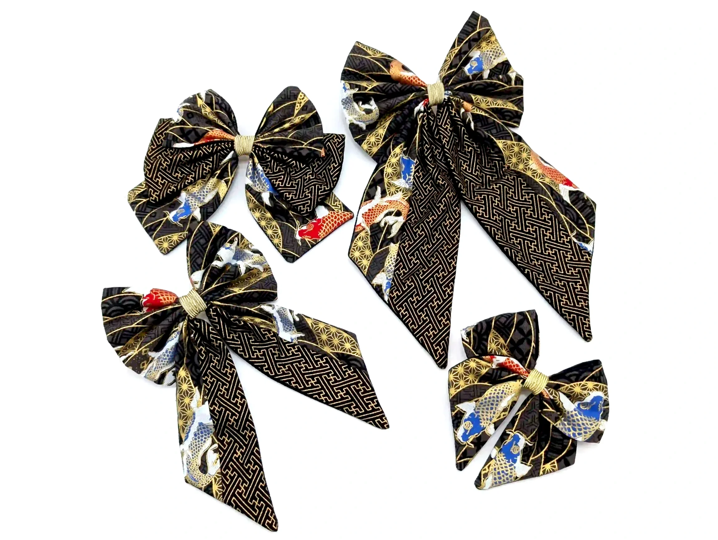 Collection de nœuds cheveux Koï noir en quatre tailles, tissu Sayagata noir et or orné de carpes japonaises dorées et bleues, confectionnés à la main en Occitanie.