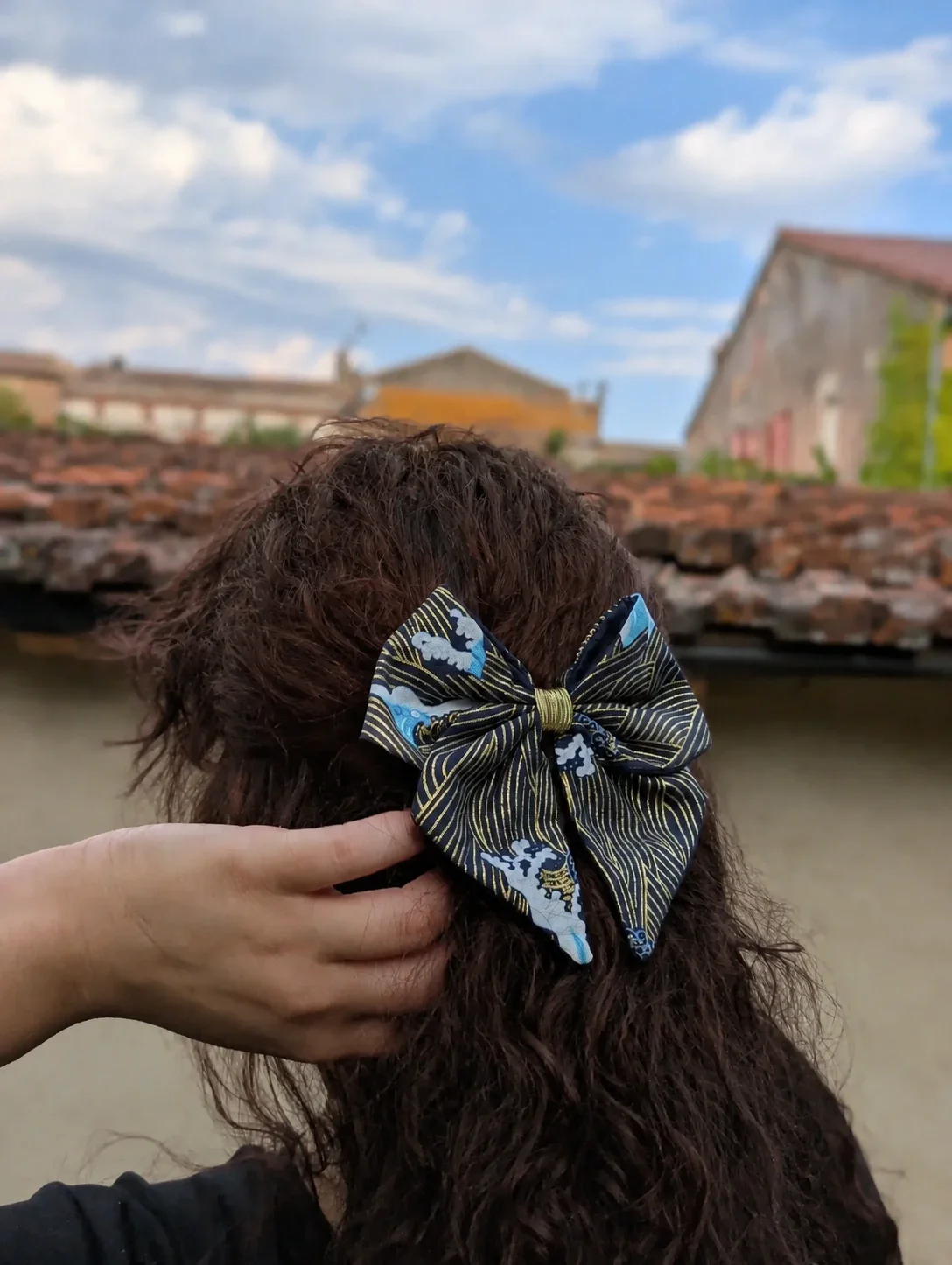 Nœud pour cheveux Nami to Awa noir et bleu à motifs japonais porté sur cheveux longs, vue rapprochée.