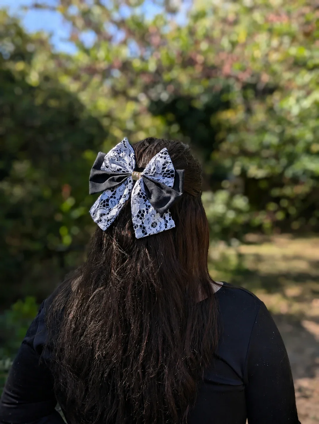 Nœud pour cheveux noir et dentelle blanche porté sur cheveux longs, vue de dos.