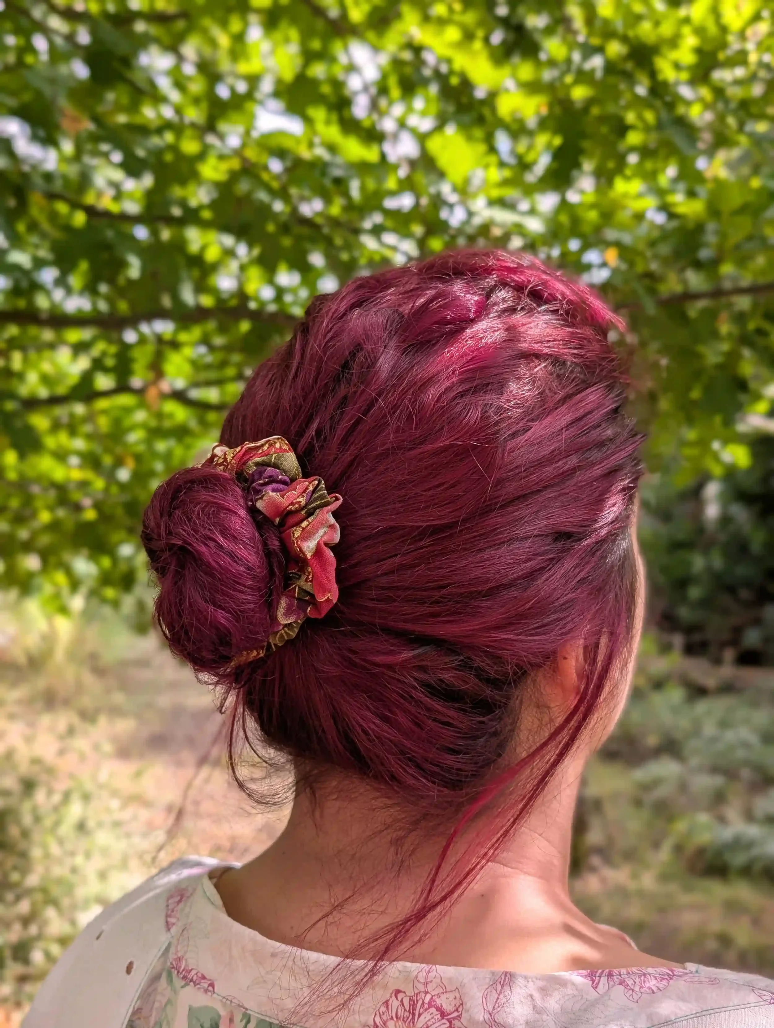 Chouchou cheveux Tsuru porté sur un chignon, motif floral japonais doré, tons rouge et prune.
