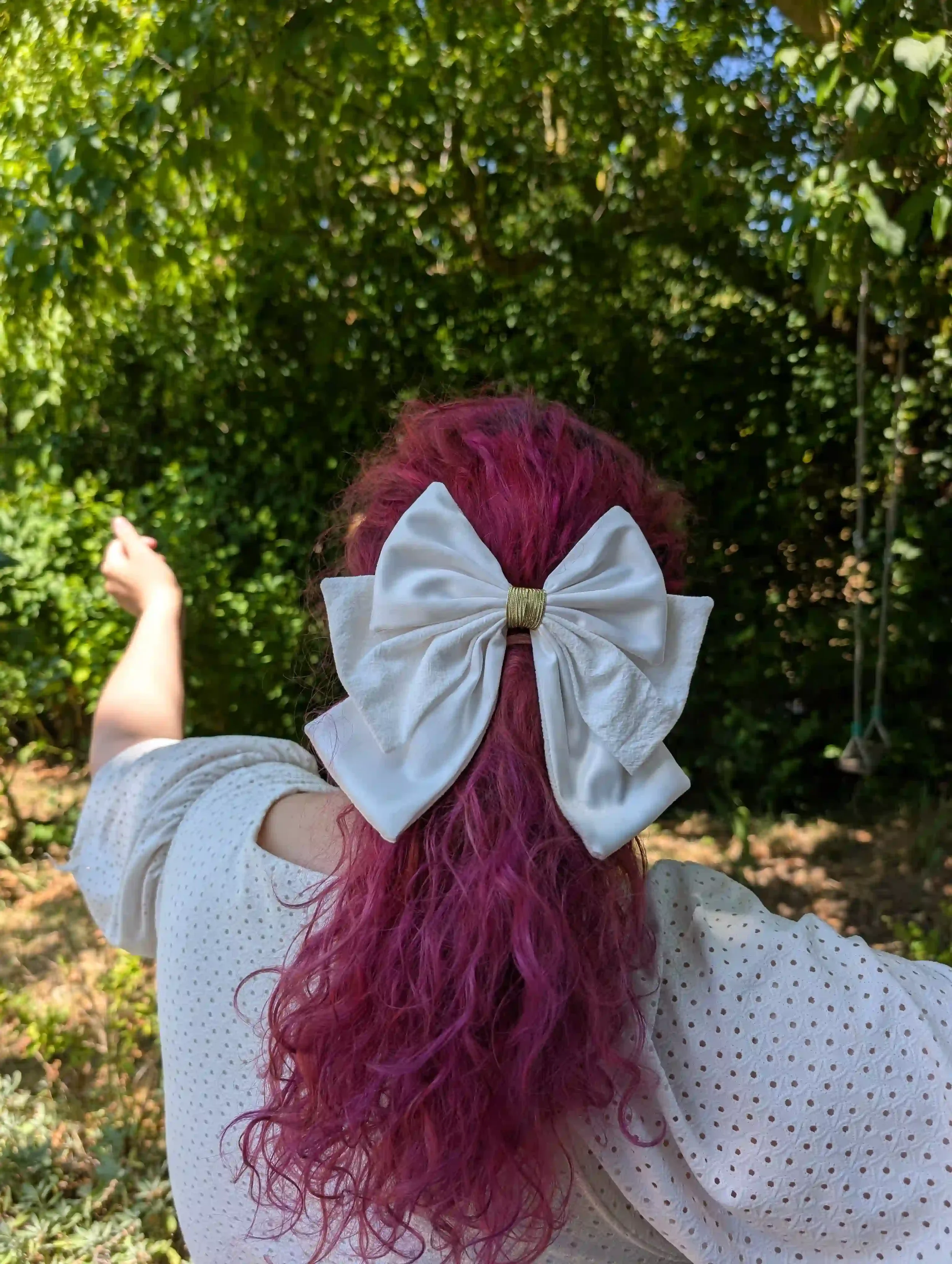 Grand nœud blanc pour cheveux porté en demi-queue, exemple de grande taille sur cheveux longs.
