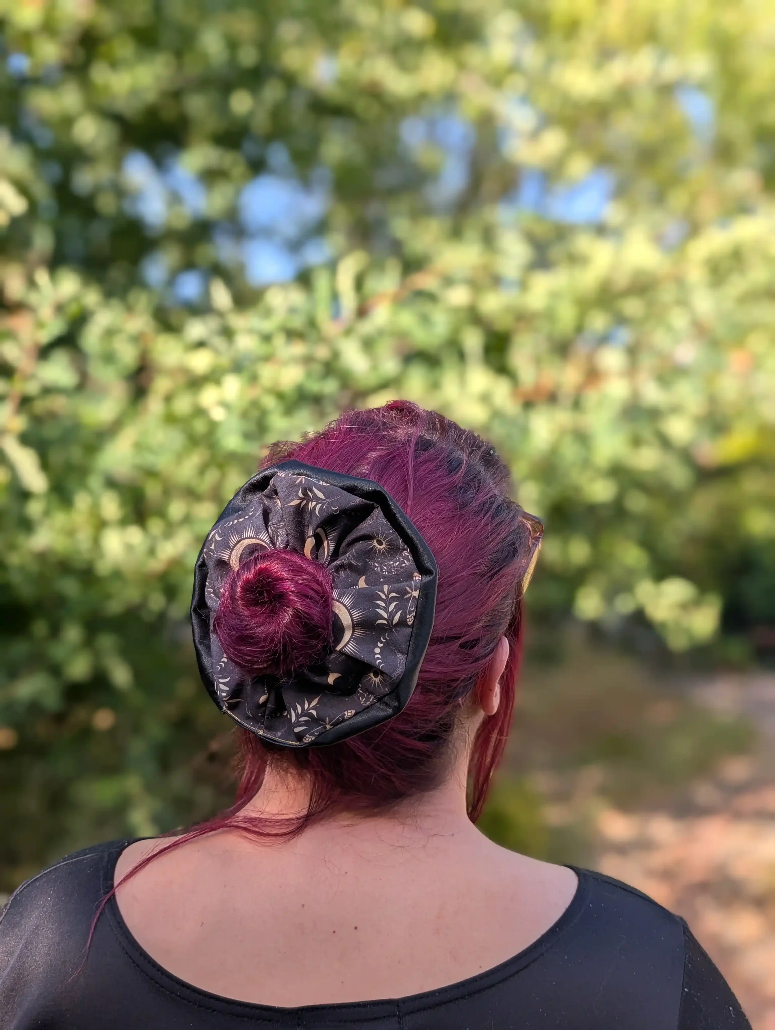 Grand chouchou Dark Moon avec satin noir porté autour d’un chignon