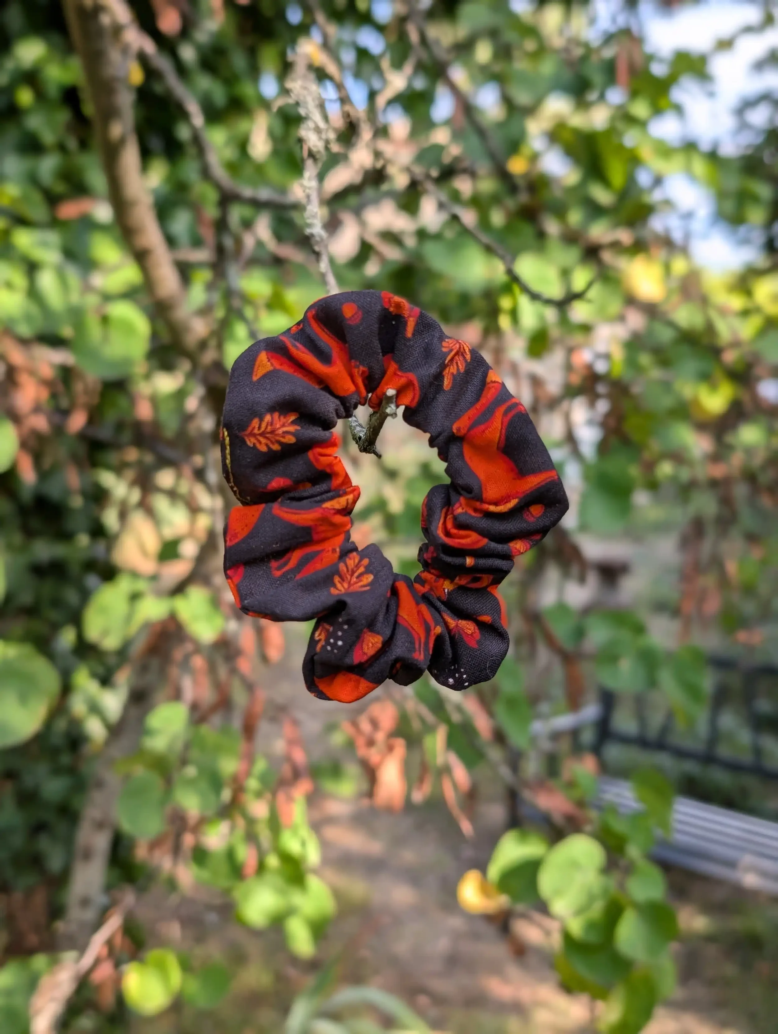 Petit chouchou Renards noir et rouille suspendu à une branche, tissu imprimé à motifs de renards