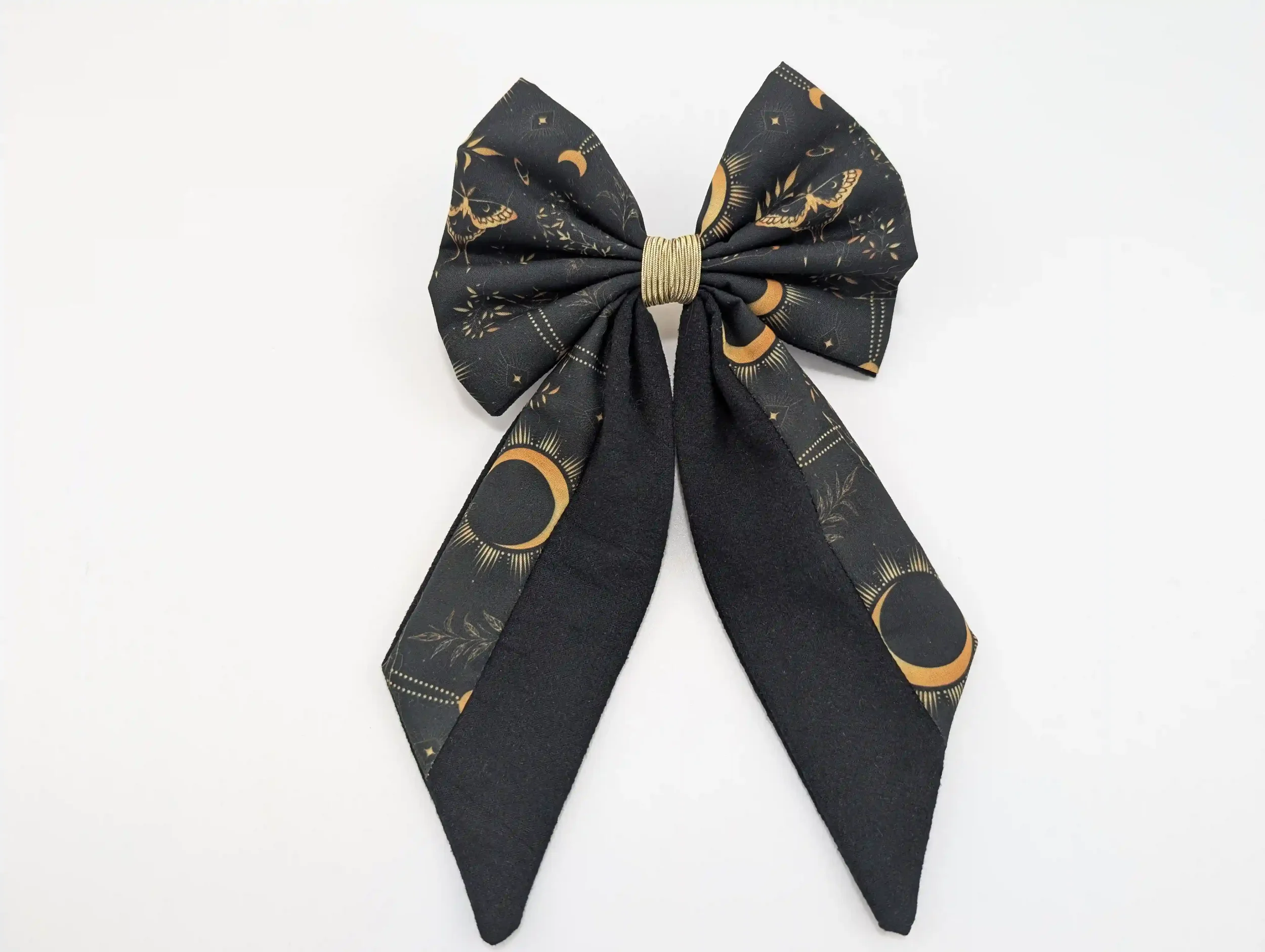 Nœud pour cheveux Moon taille L, en tissu noir à motifs célestes dorés et finition centrale dorée.