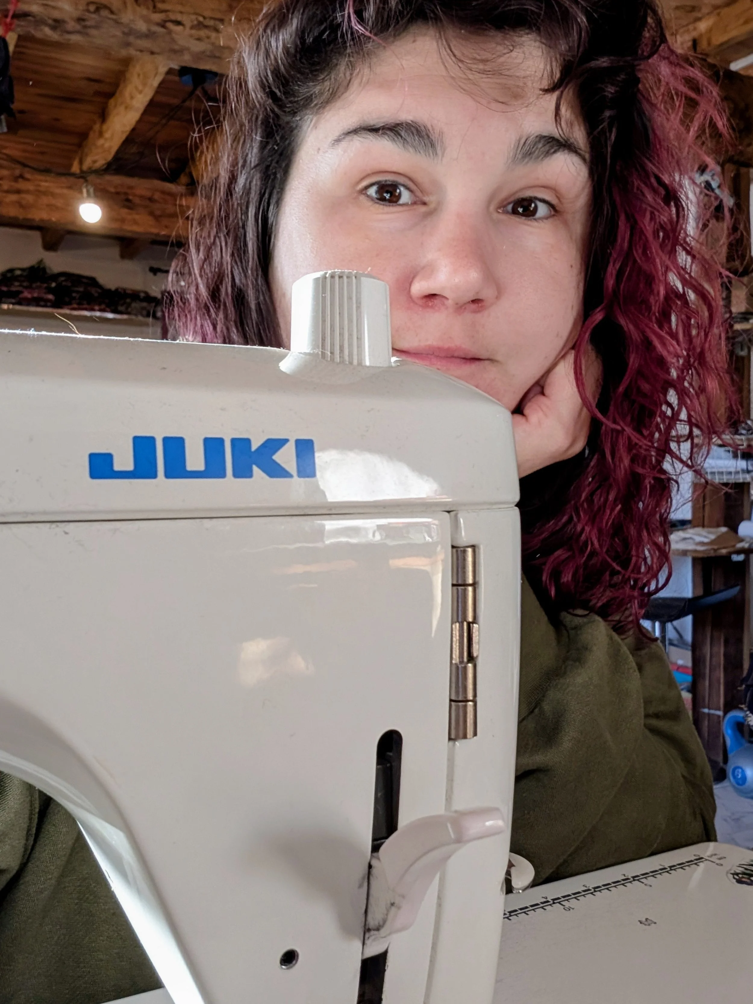Artisane couturière derrière sa machine à coudre dans son atelier, réalisant des accessoires textiles faits main en Occitanie.