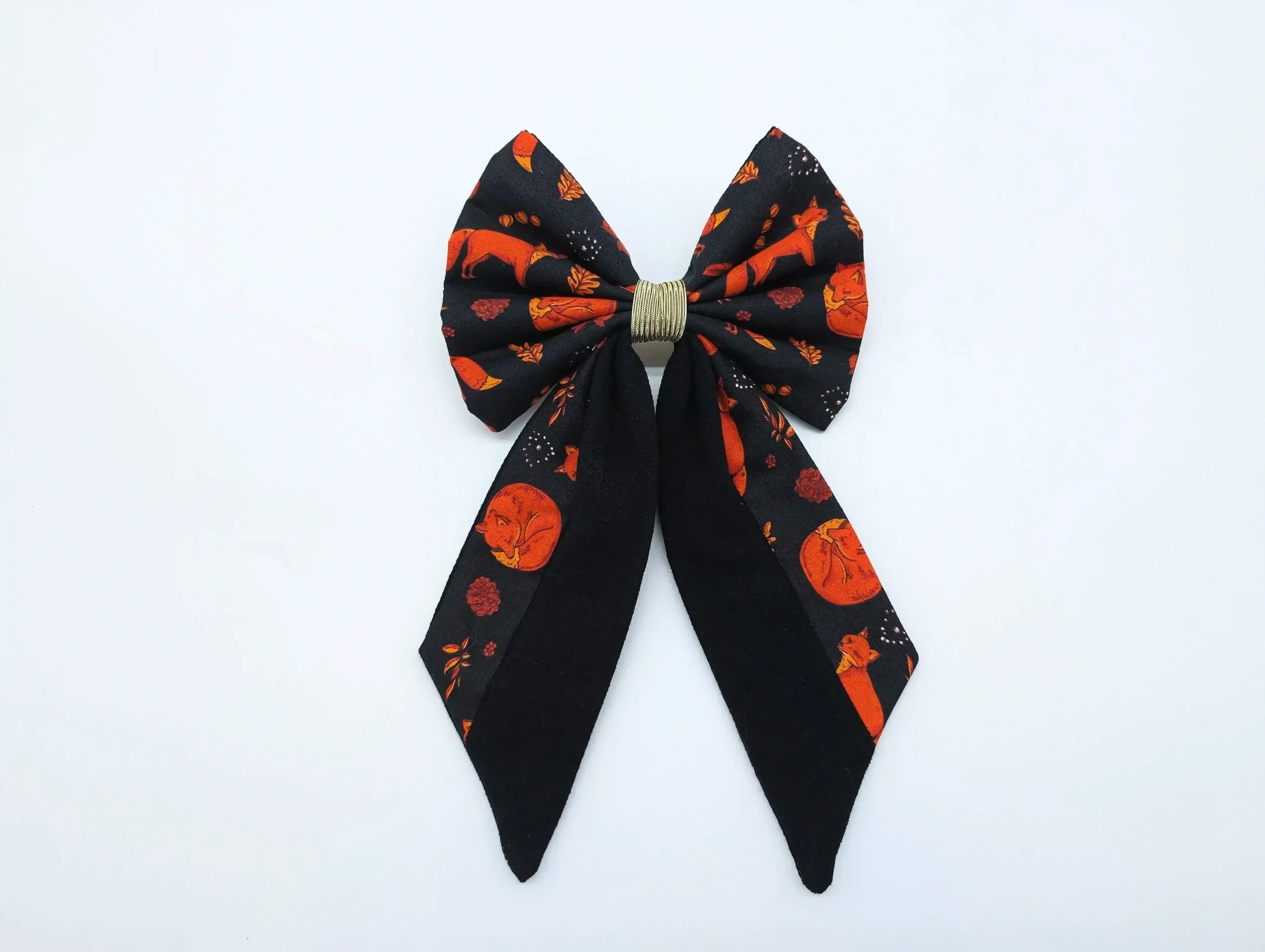 Nœud pour cheveux Renards taille L, en tissu noir à motifs de renards roux, avec longues pointes et centre doré.