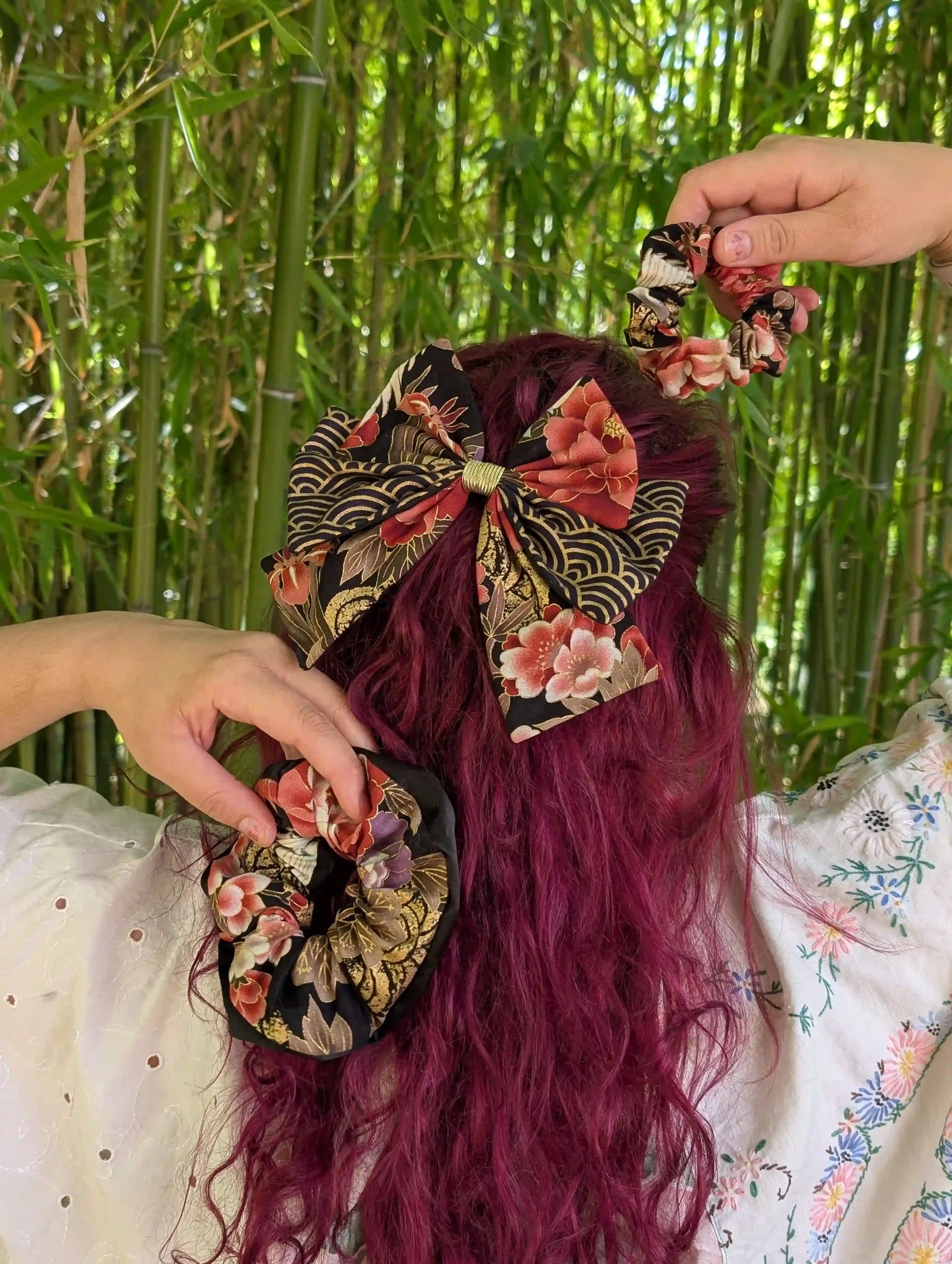 Nœud pour cheveux Tsuru noir et or porté en demi-queue, accompagné de petits chouchous assortis dans le même tissu japonais.