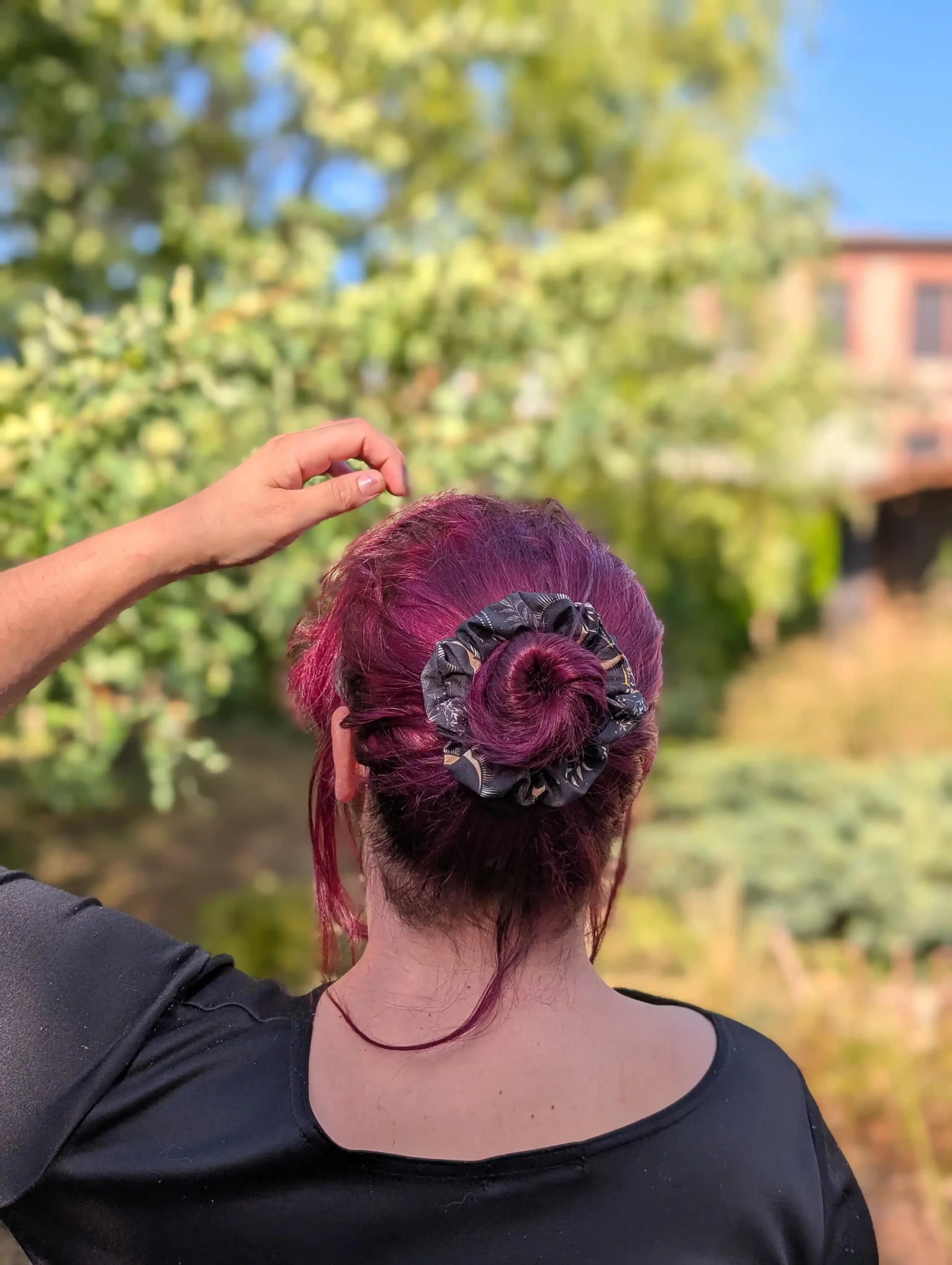 Petit chouchou Dark Moon porté autour d’un chignon sur cheveux bordeaux