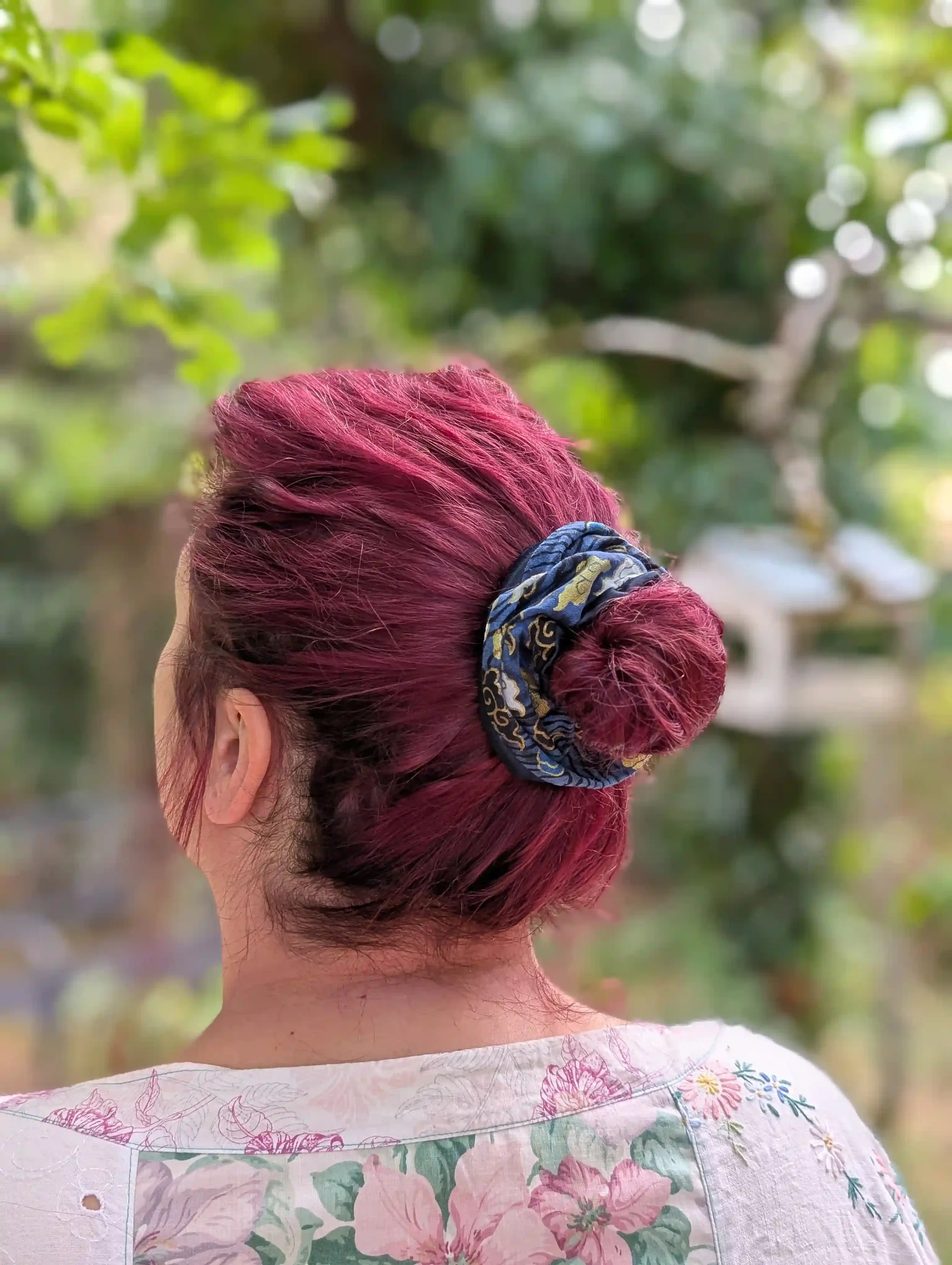 Grand chouchou cheveux Cloud bleu enroulé en double tour autour d'un chignon, motif nuage japonais doré et satin bleu marine.