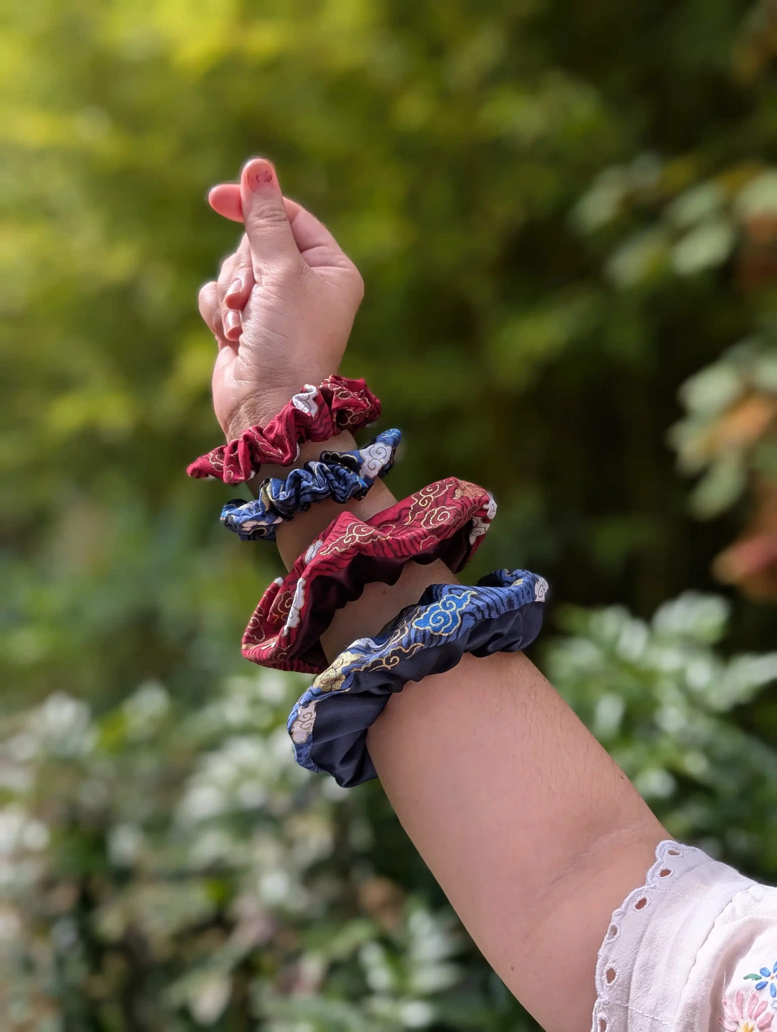 Chouchous cheveux Cloud rouge et bleu portés au poignet comme des bracelets, motif nuage japonais doré.