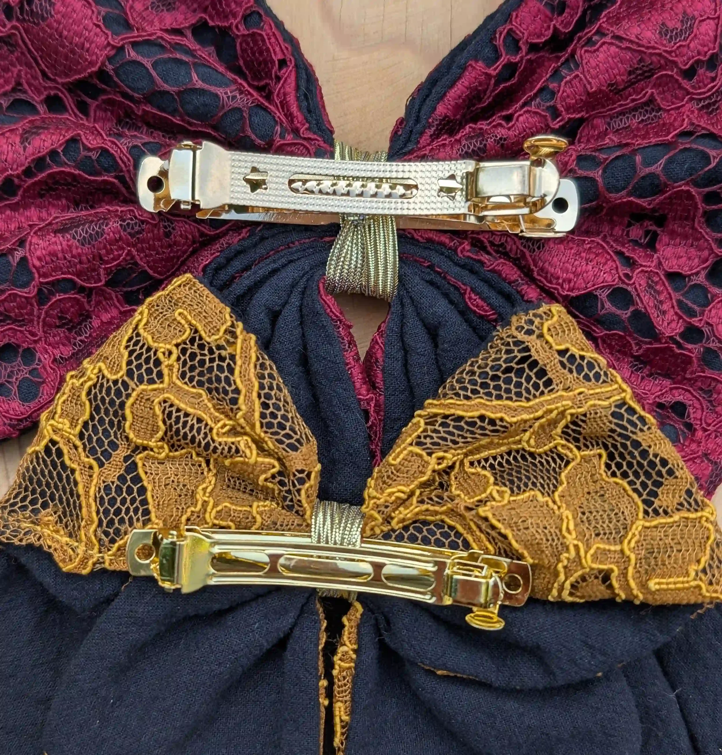 Vue du dos des barrettes métalliques dorées utilisées sur les nœuds pour cheveux de la collection Dentelle.