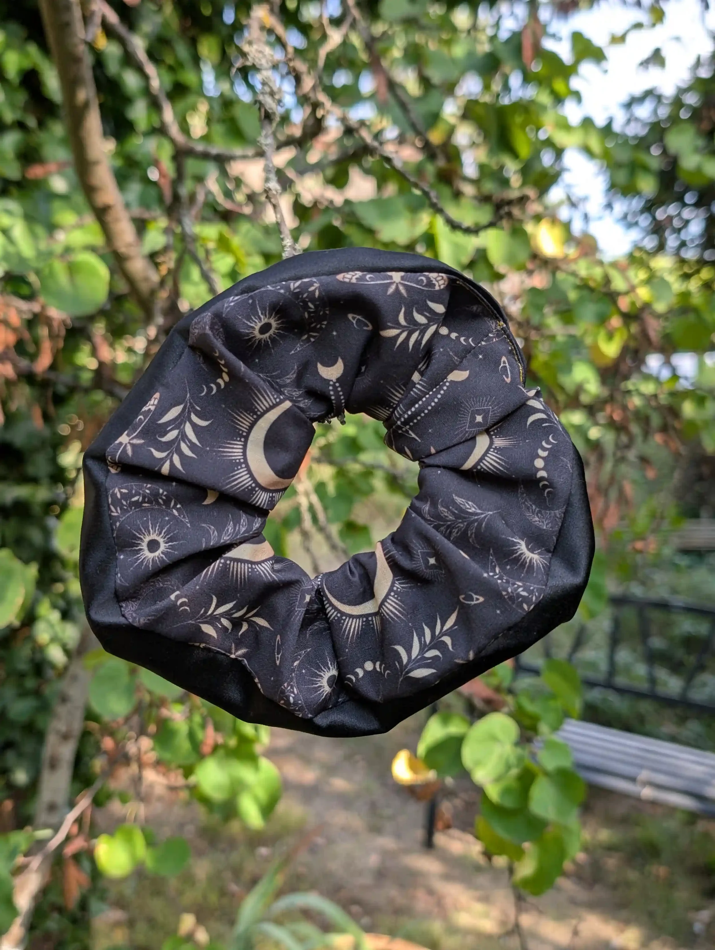 Grand chouchou Dark Moon suspendu à une branche, tissu céleste noir et doré avec satin noir