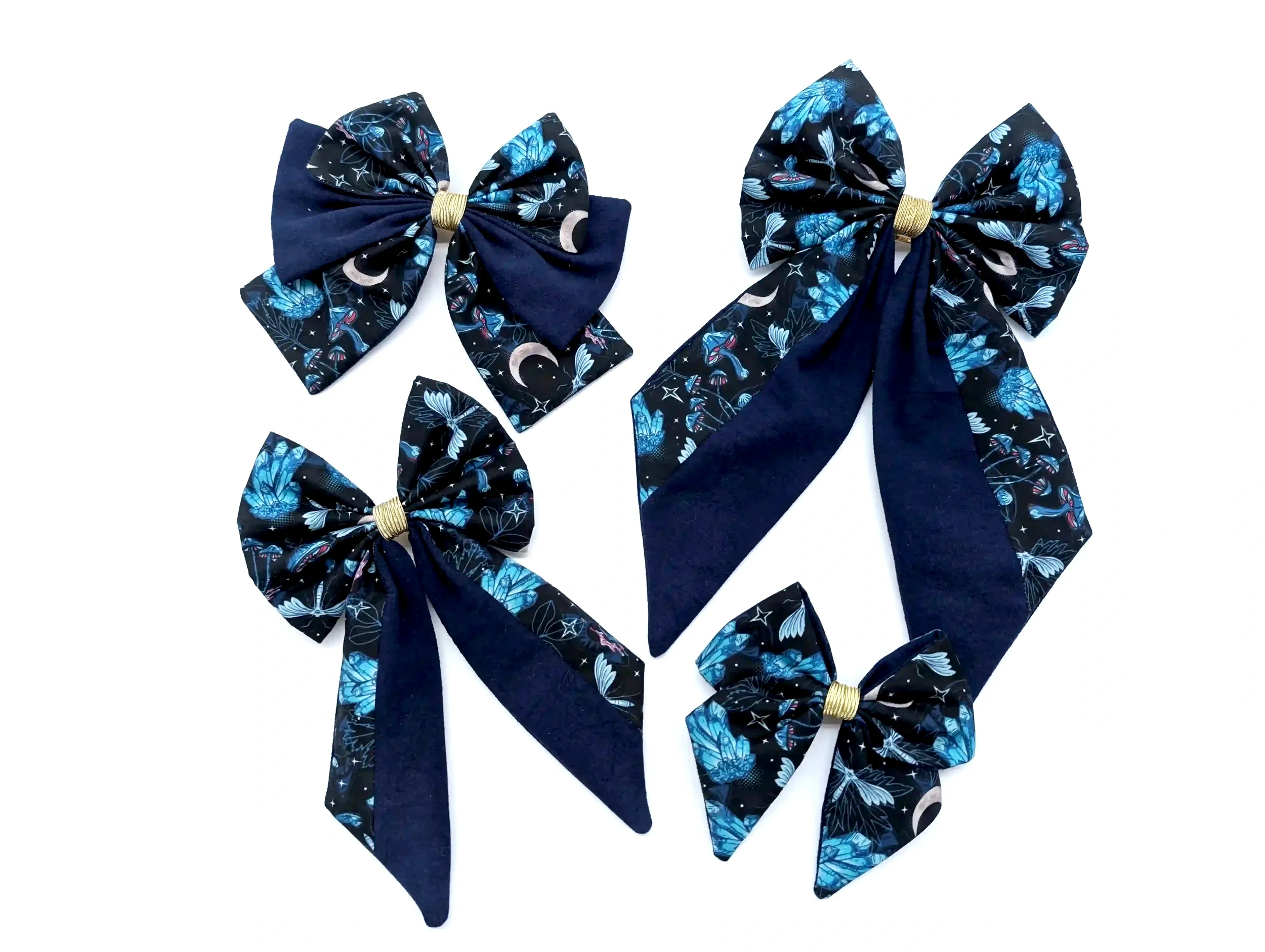 Collection des quatre tailles S à XL du nœud pour cheveux Cristal, en tissu noir et bleu à motifs mystiques, avec pointes bleu nuit.