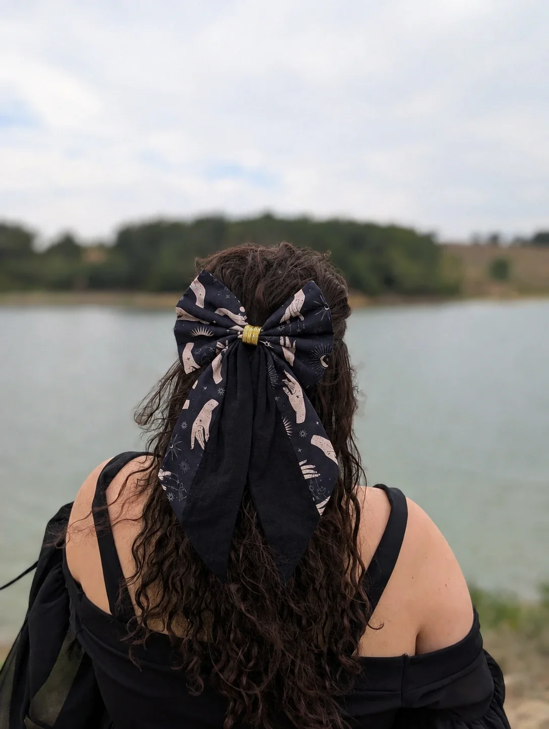 Très grand noeud pour cheveux Oracle Nocturne noir, avec longs pans unis et motifs de sorcière céleste.