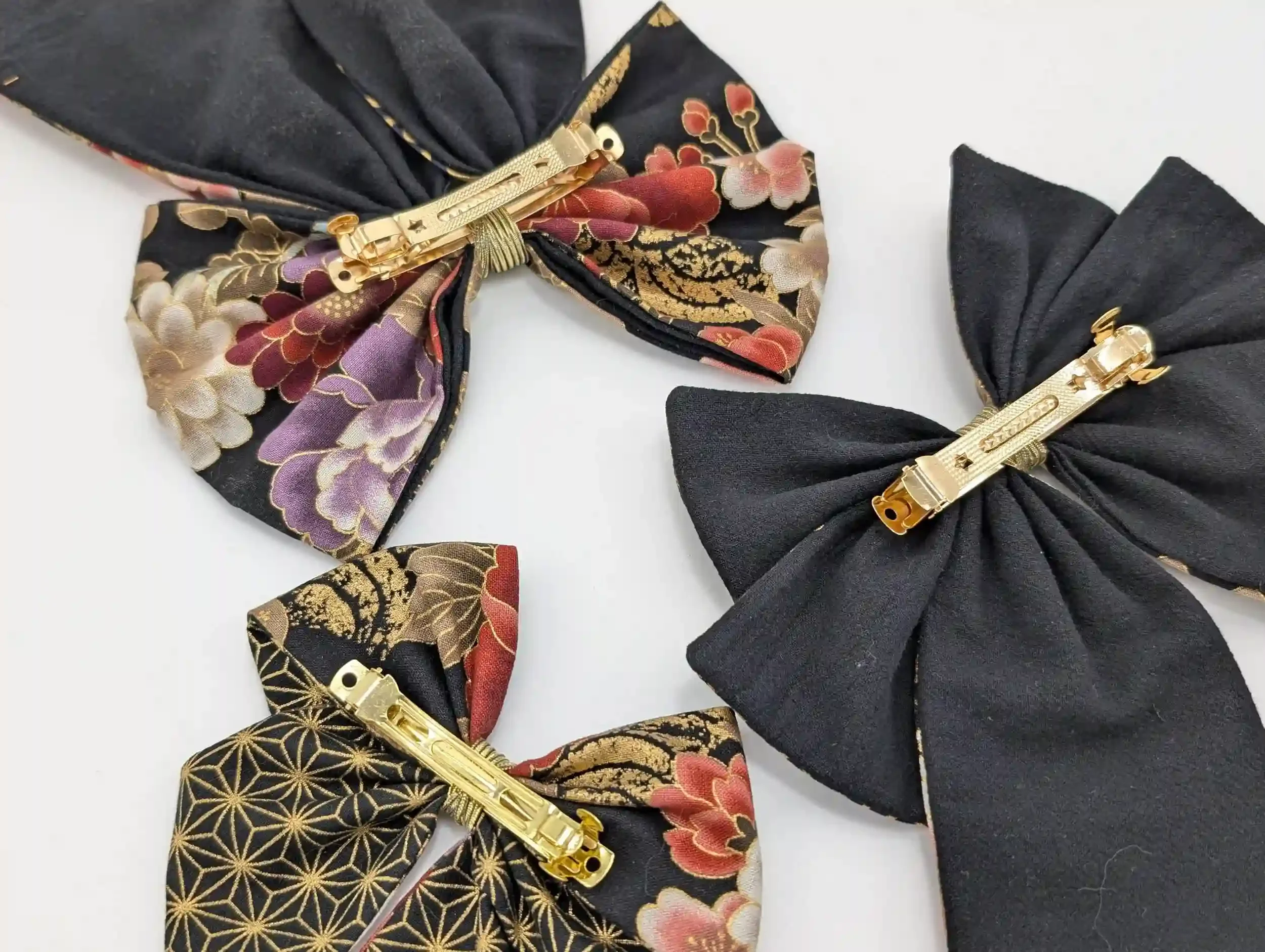 Vue arrière des nœuds Tsuru noir et or montrant les barrettes métalliques dorées assurant une excellente tenue.