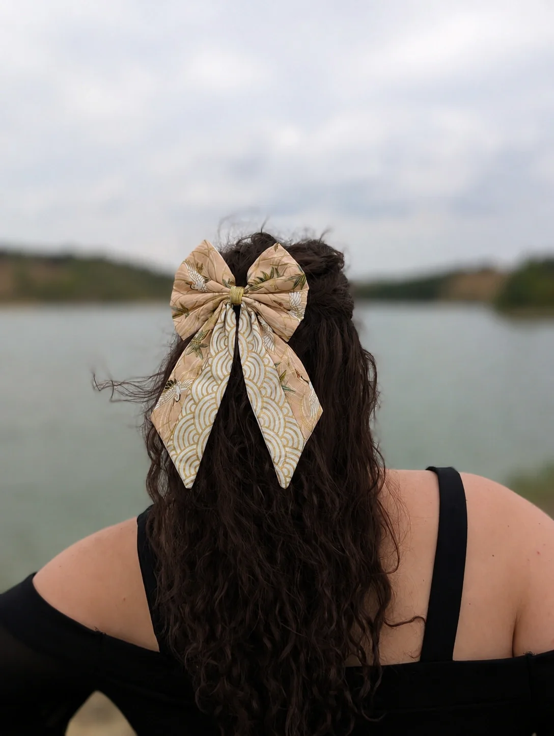 Grand noeud barrette Tsuru to Take à grues et bambou, avec pans Seigaiha blancs et dorés, porté sur cheveux longs.
