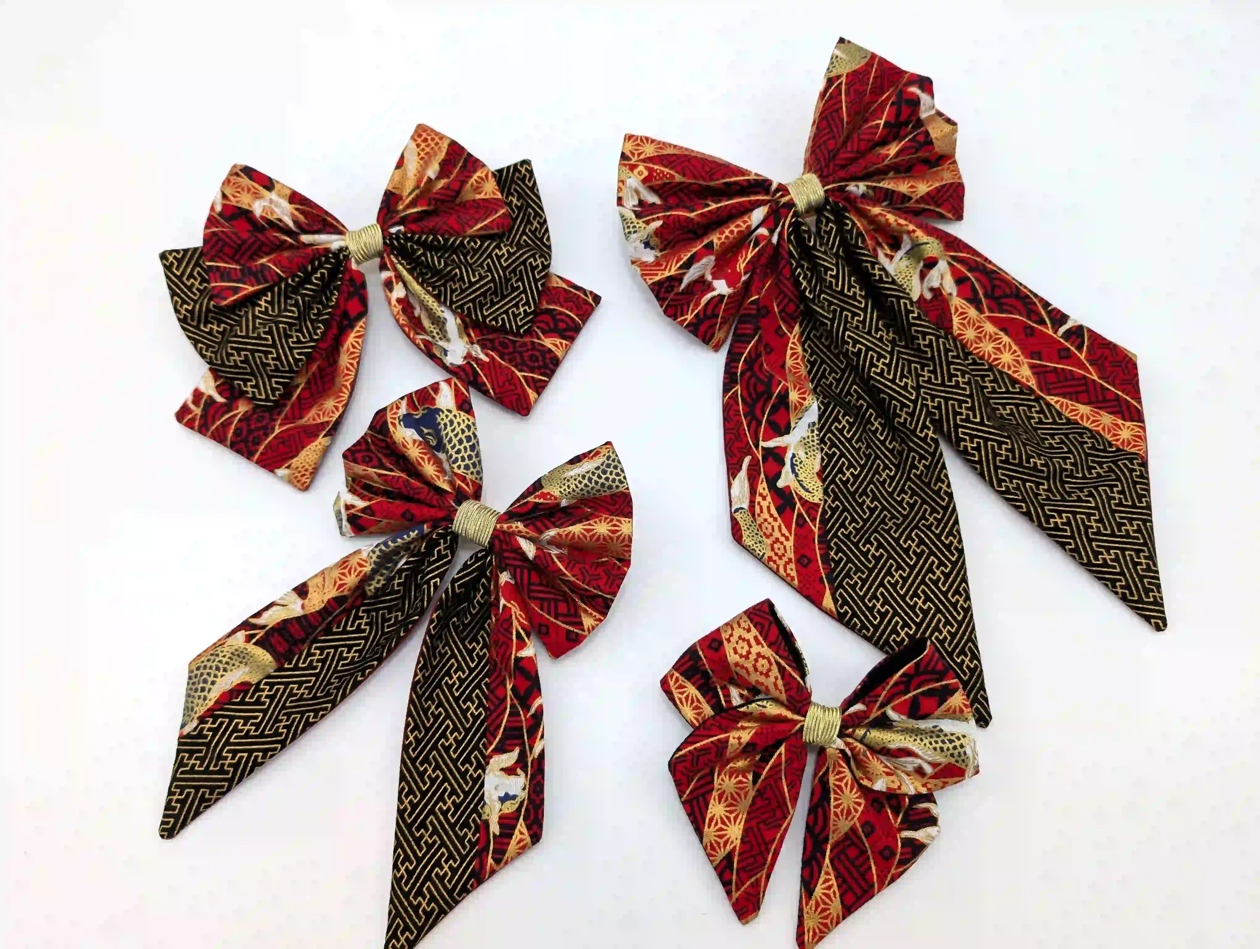 Collection de nœuds cheveux Koï rouge en quatre tailles, tissu bordeaux associé au motif Sayagata noir et or à carpes japonaises, confectionnés à la main en Occitanie.