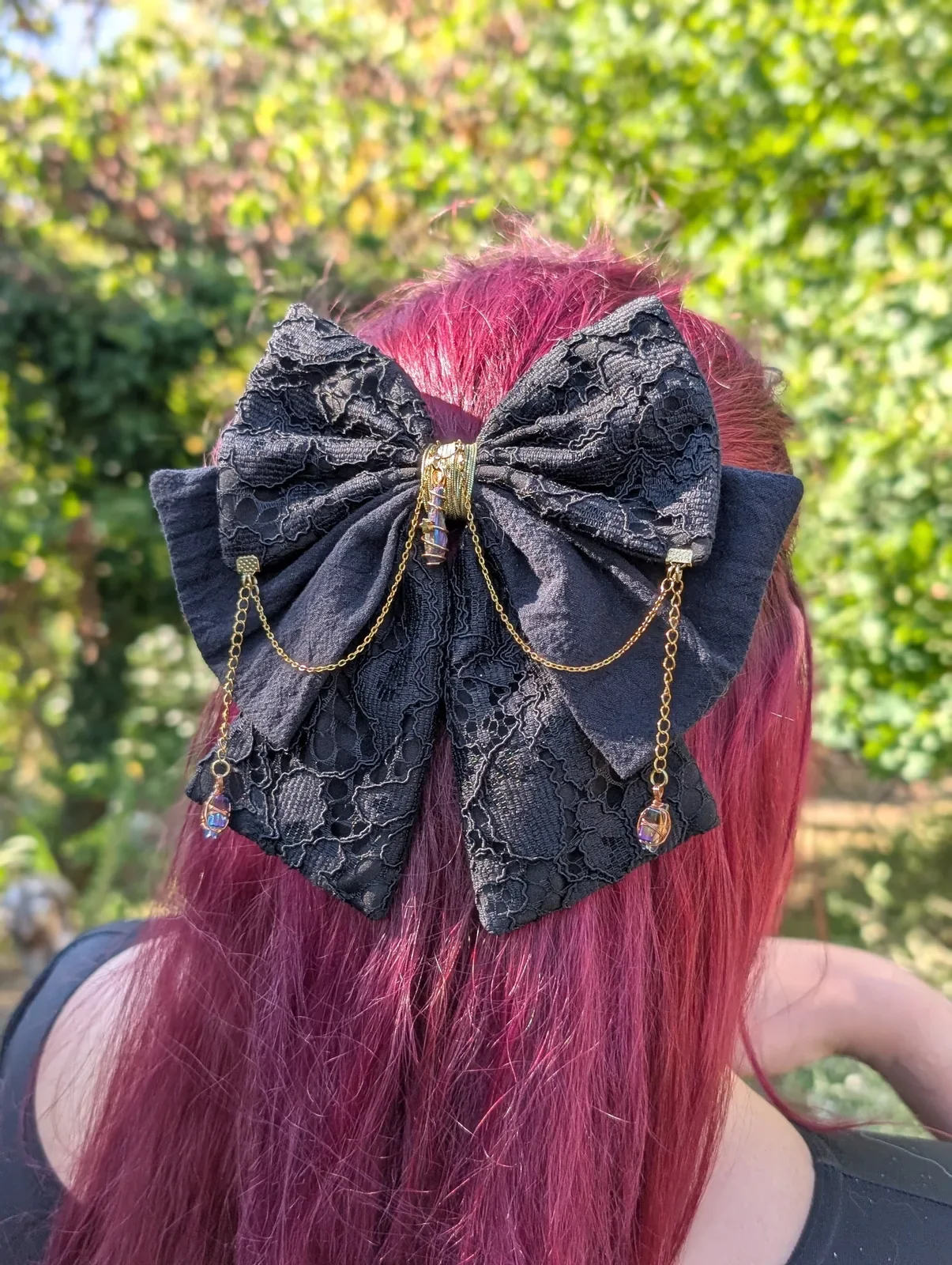 Noeud barrette Dentelle noir, taille M, avec cristal central et étoiles suspendues sur les côtés.