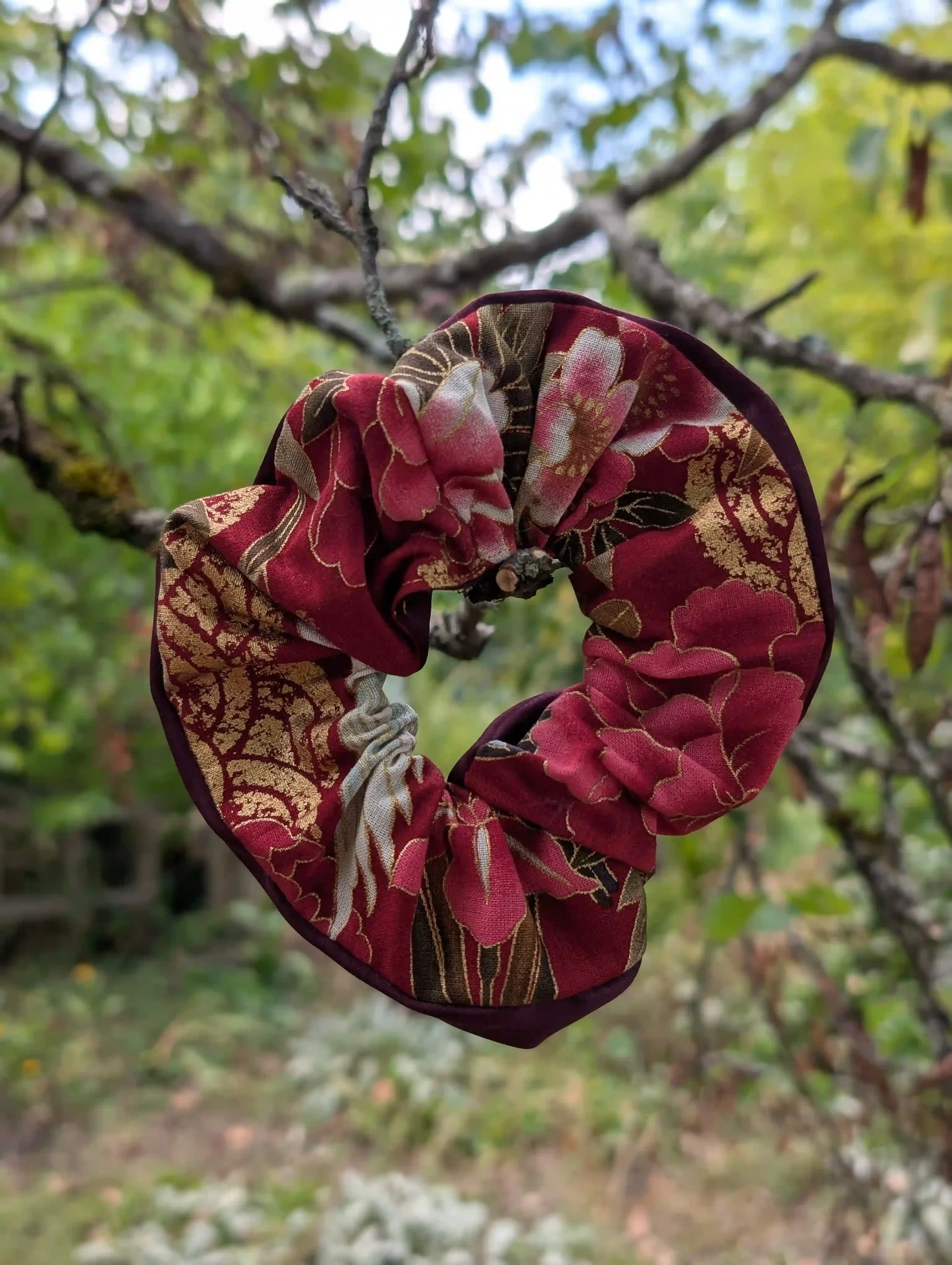 Grand scrunchie cheveux Tsuru, motif floral japonais doré sur fond bordeaux.