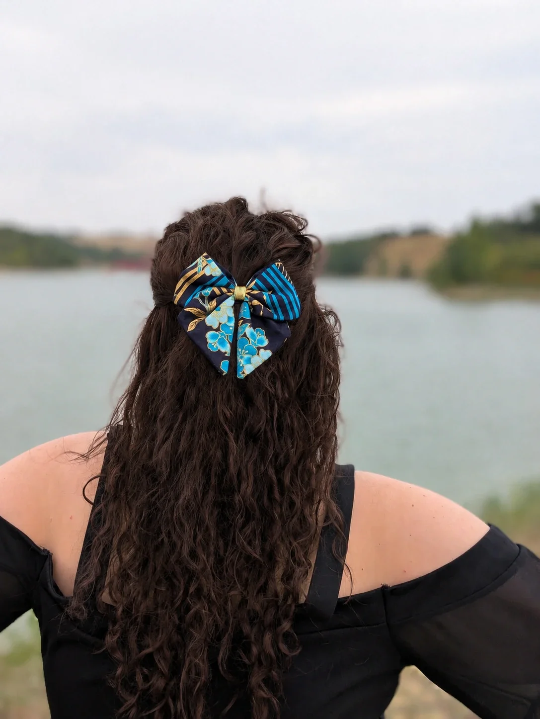 Petit Nœud Hana to Nami à fleurs bleues et rayures dorées porté sur une demi-queue, vue de dos.