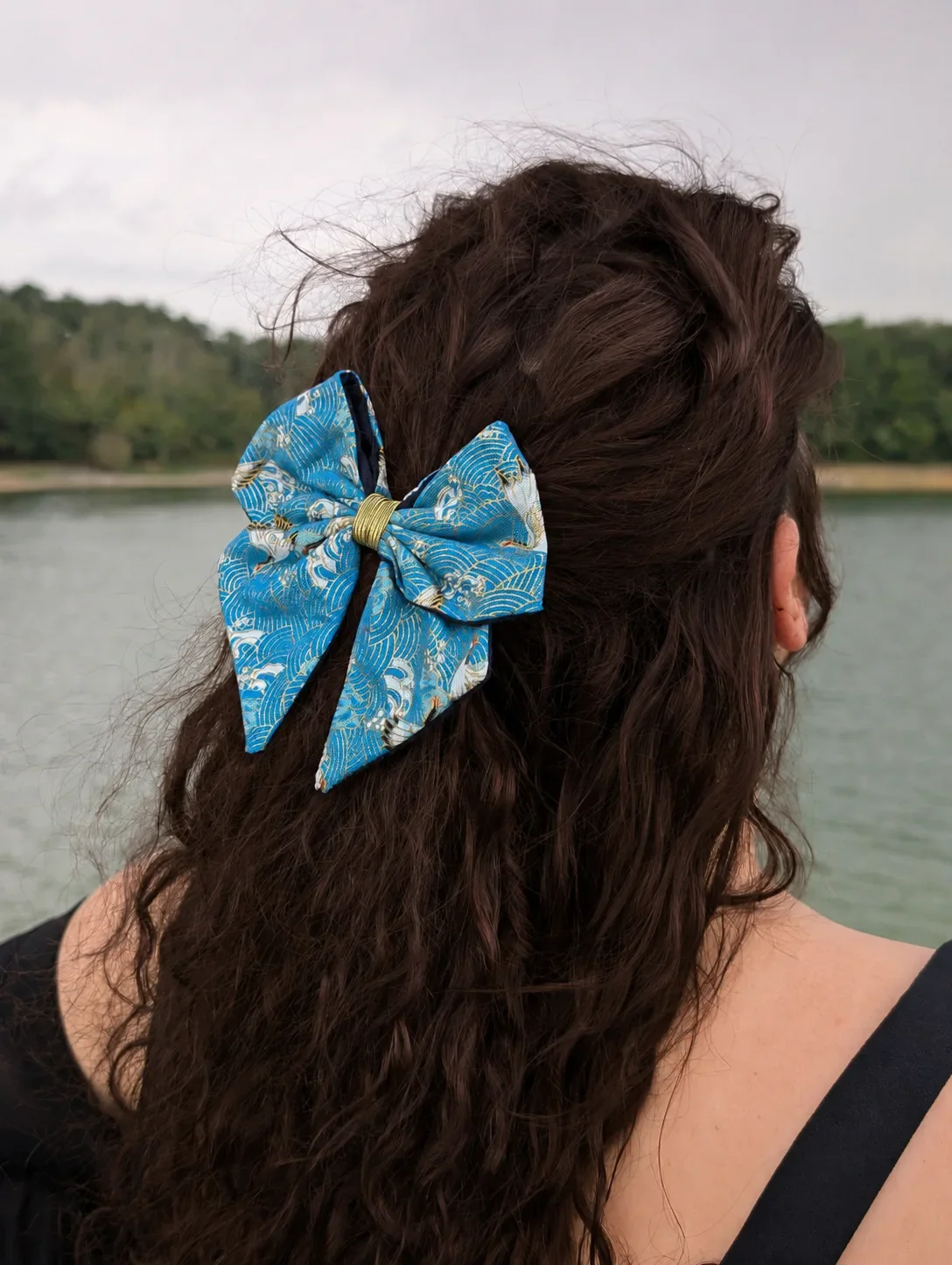 Noeud pour cheveux Sora to Umi bleu à motifs japonais porté sur cheveux longs, vue de trois quarts.