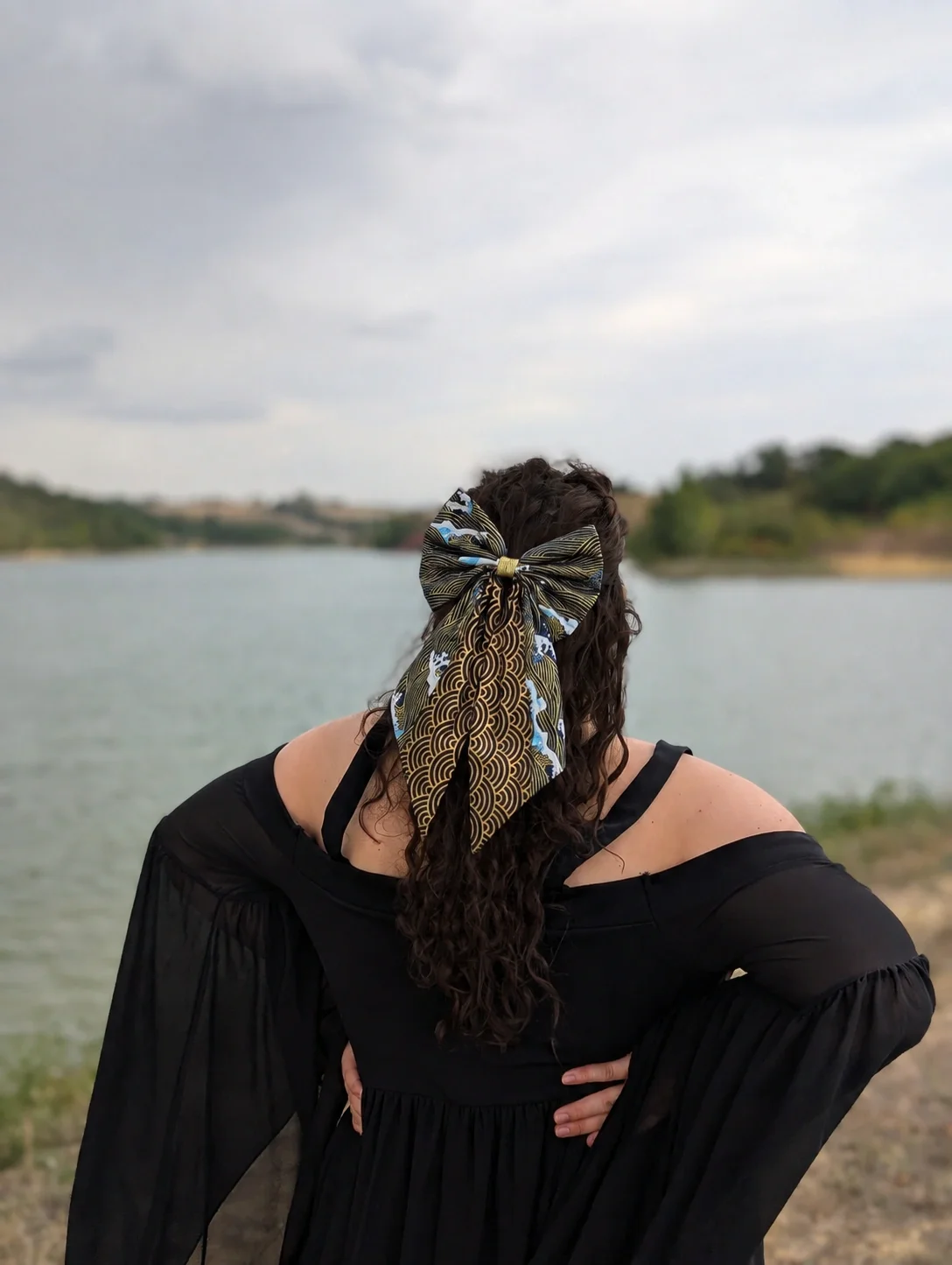 Noeud barrette Nami to Awa noir, bleu et or porté sur une demi-queue de cheveux.