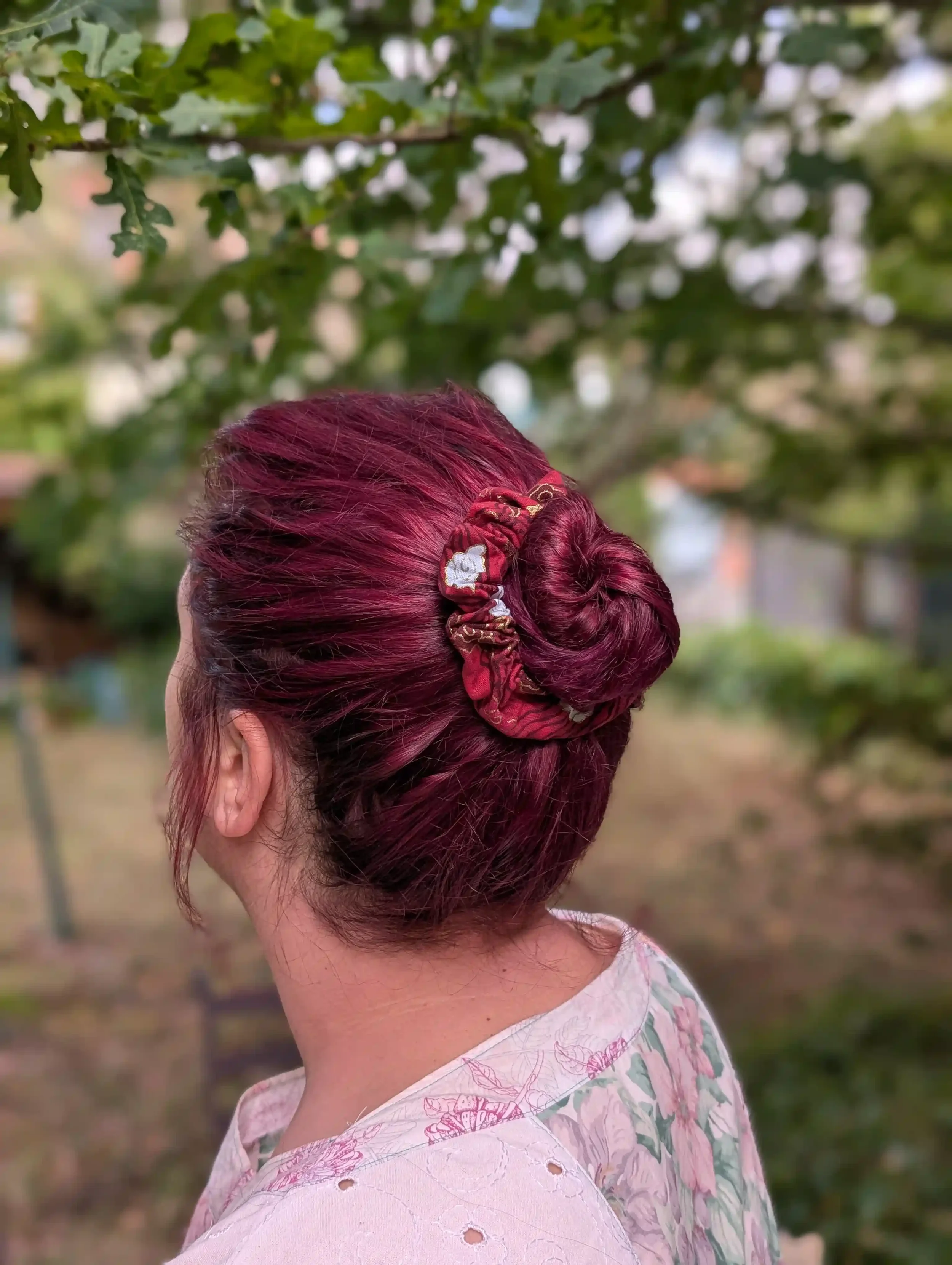 Petit chouchou cheveux Cloud rouge porté sur un chignon, motif nuage japonais doré.