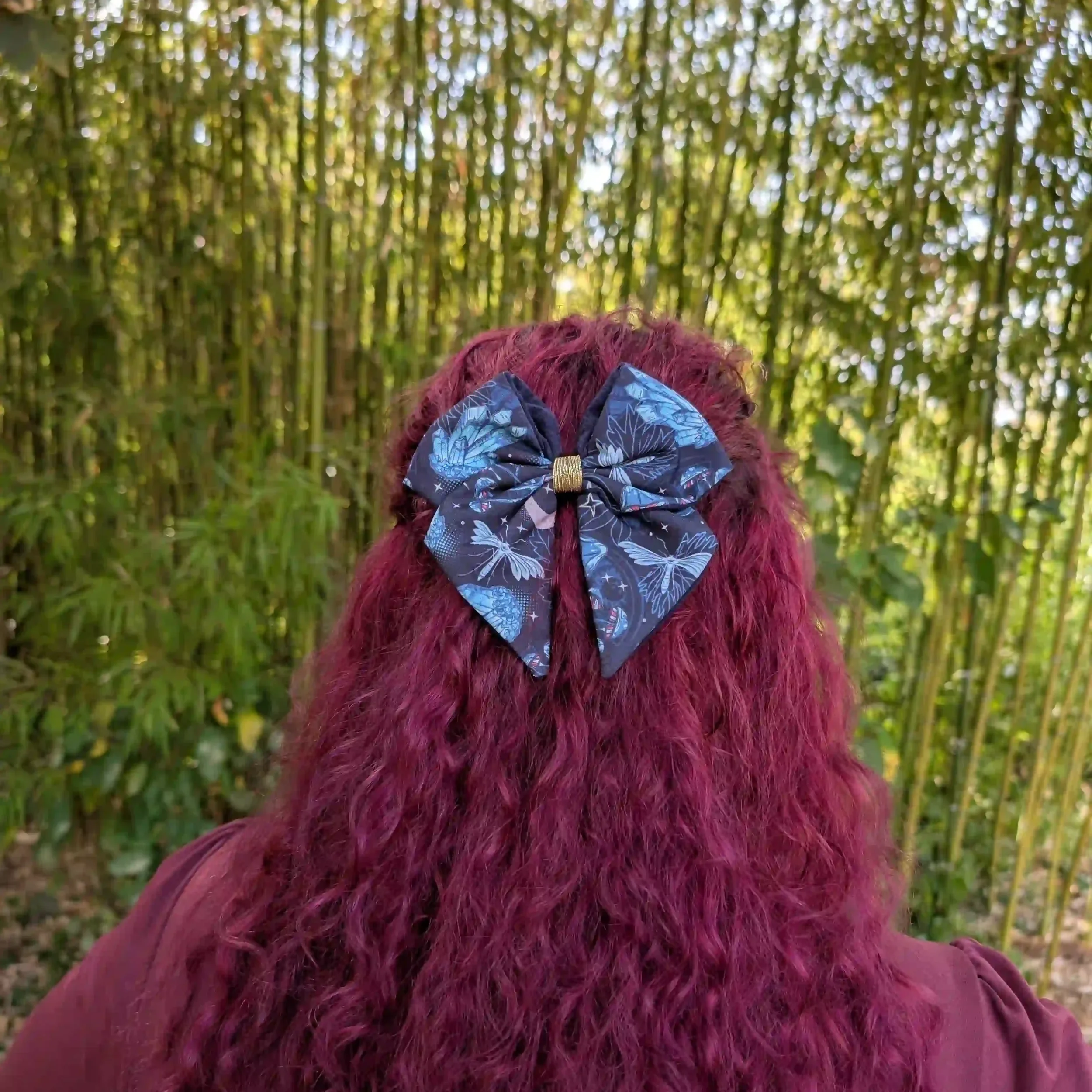 Nœud pour cheveux noir et bleu de la collection Cristal porté sur cheveux longs, vue de dos.
