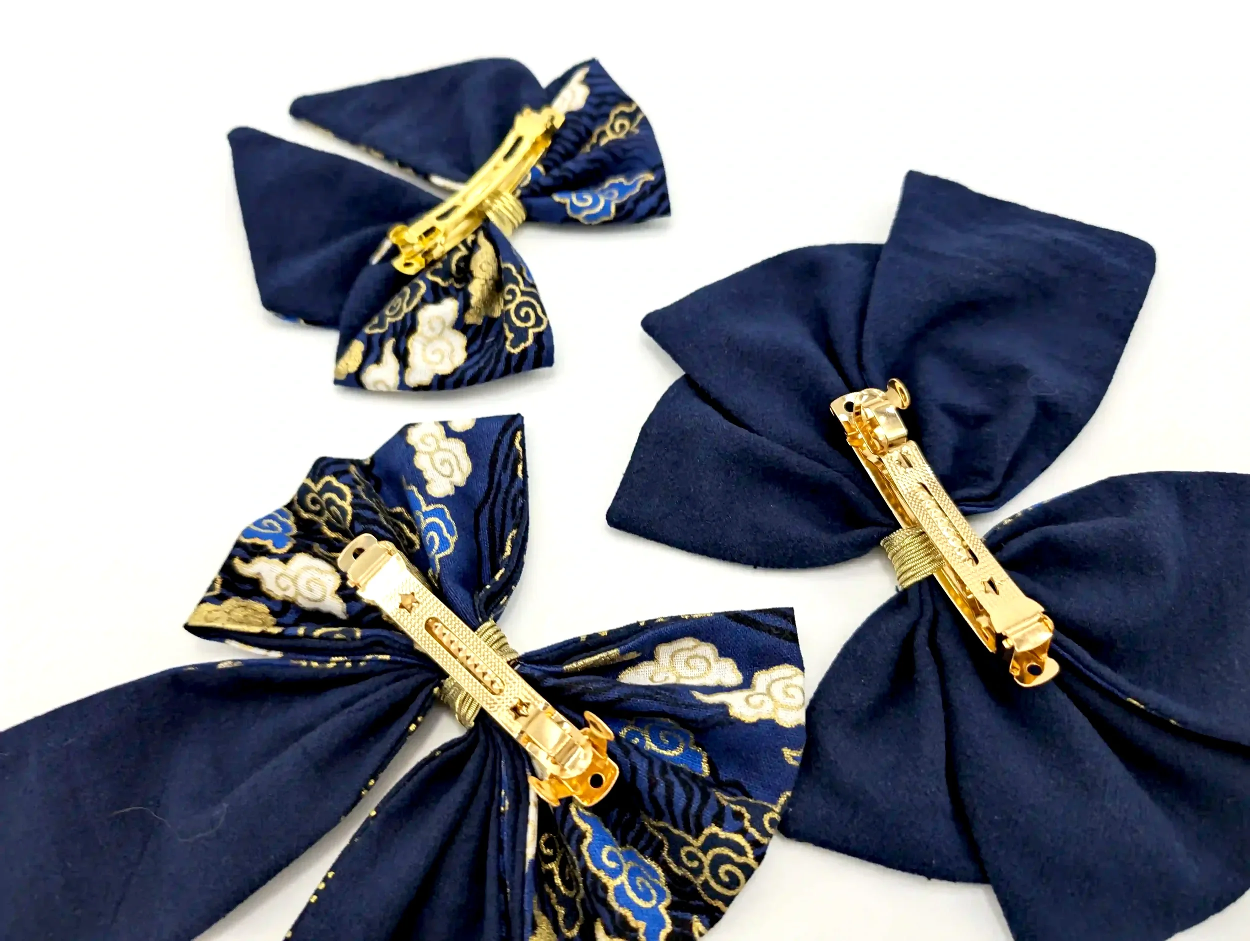 Détail des barrettes métalliques dorées sur les nœuds cheveux Cloud bleu, vue arrière en tissu uni bleu nuit.