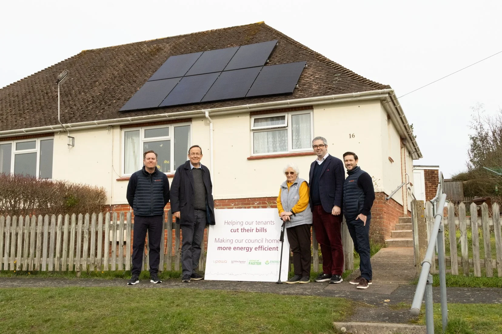 UPOWA team and Winchester City Council representatives with resident celebrating solar and battery retrofit installation at council property