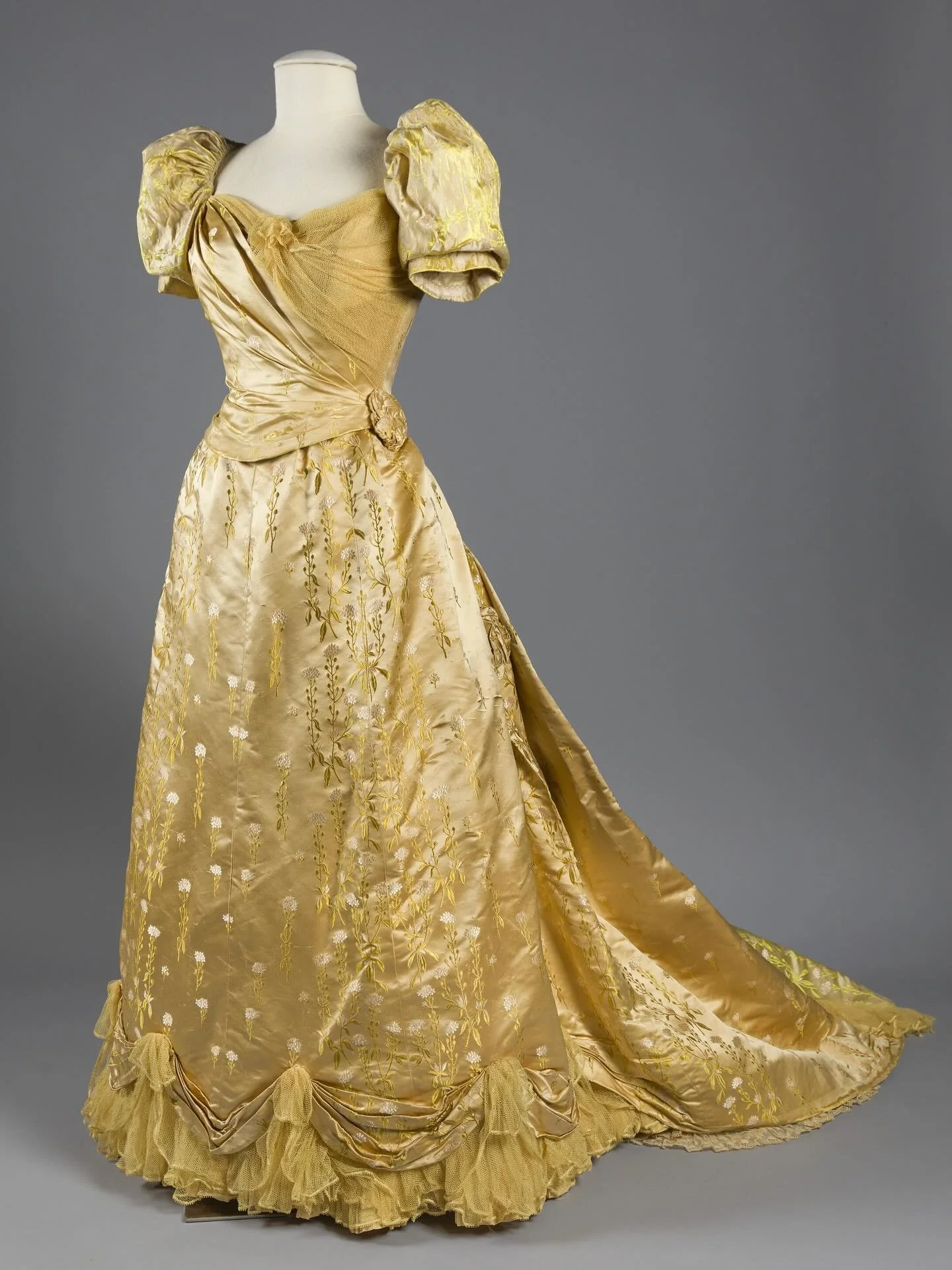 ⭐️ &ldquo;Gold and pale yellow silk satin and silk brocade evening dress embellished with netting and lace by the House of Worth. The silk brocade features a green and pink floral pattern. Dress comprises of a bodice and a skirt with a detachable tra